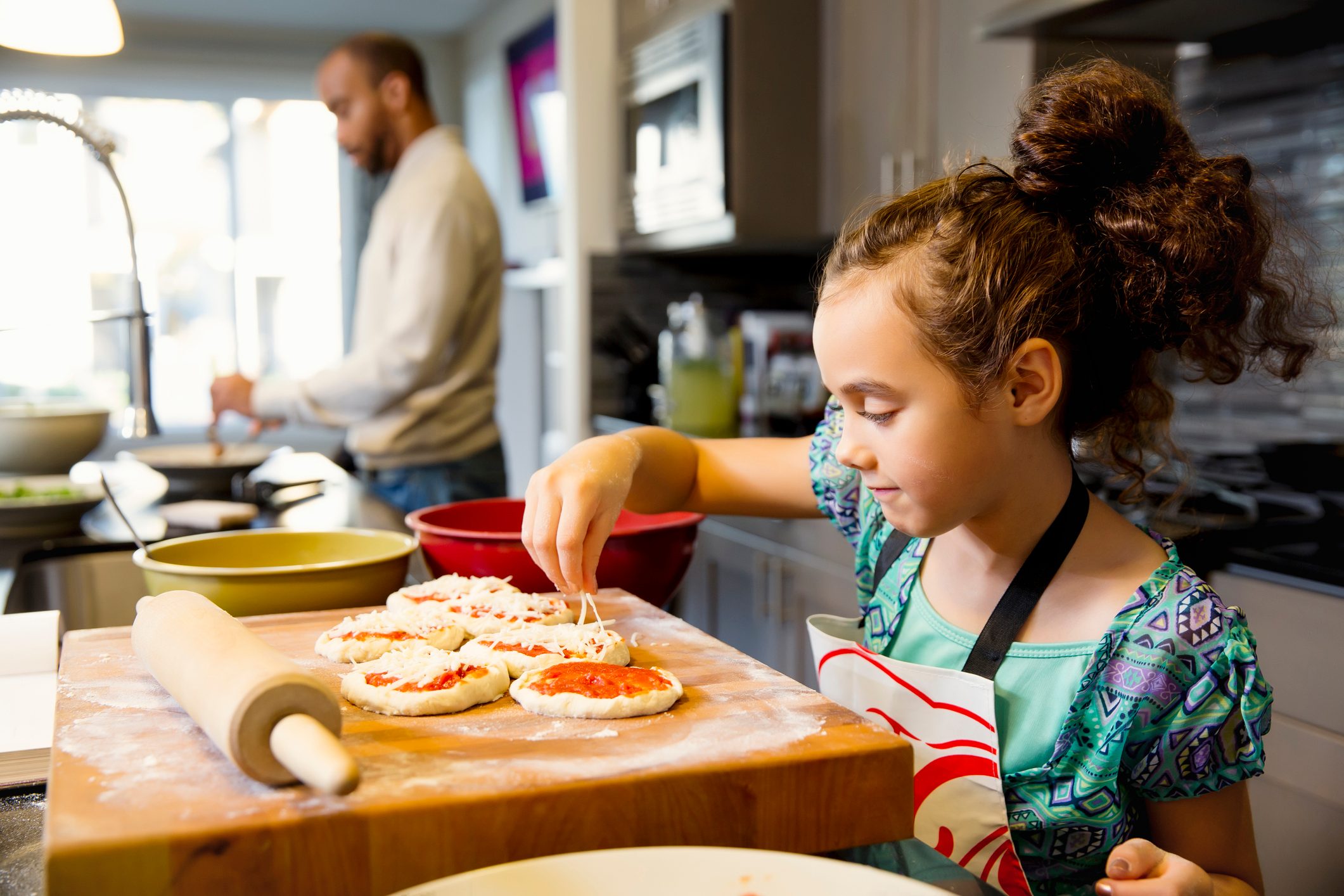 Mixed race girl cooking in kitchen