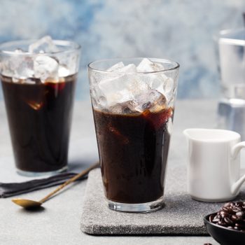 Ice coffee in a tall glass and coffee beans