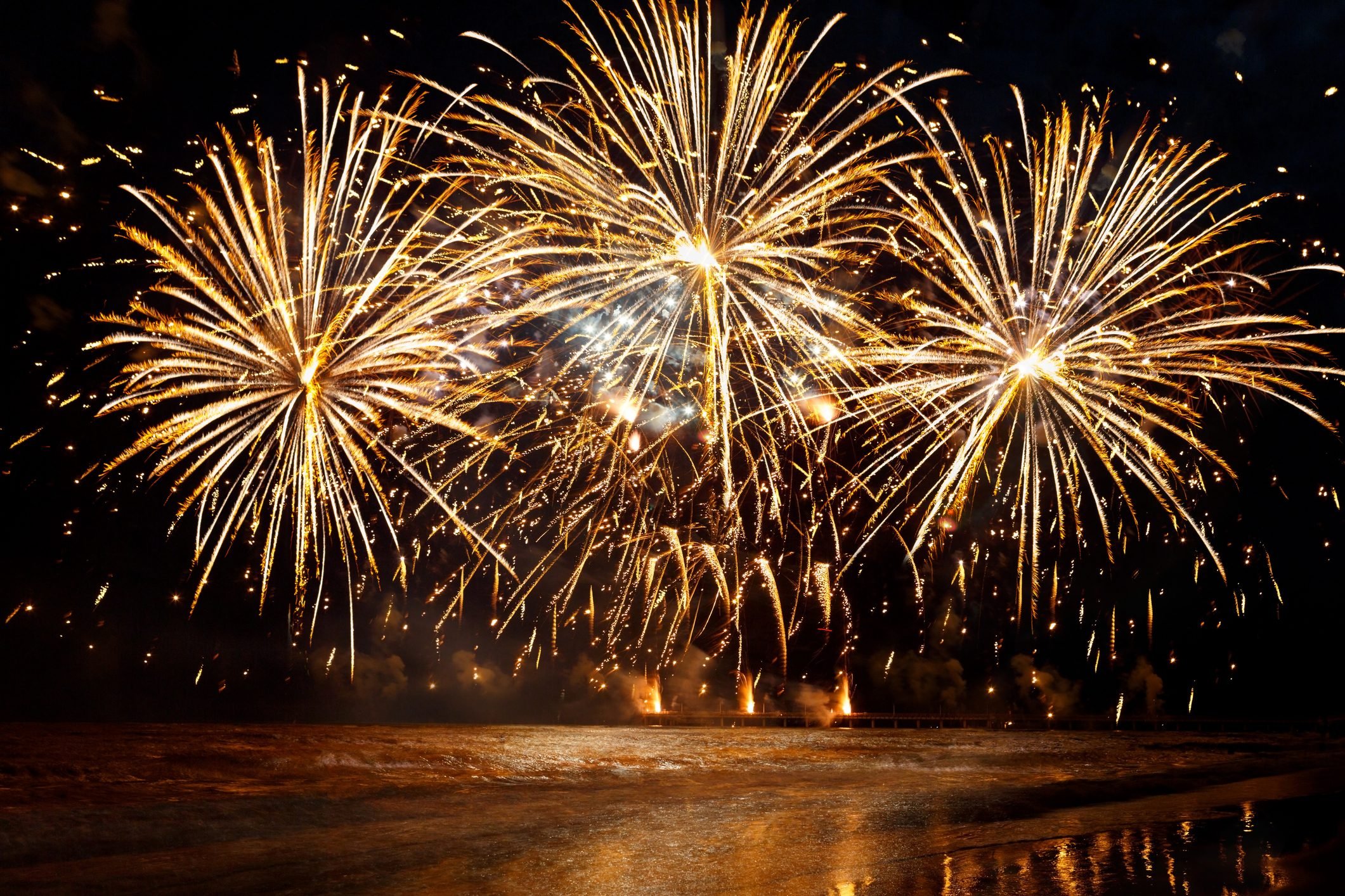 beautiful Golden fireworks over the sea on night sky background