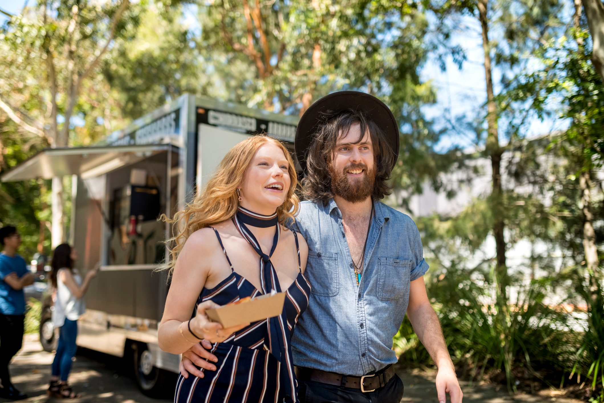 Young couple sharing snack in front of food truck