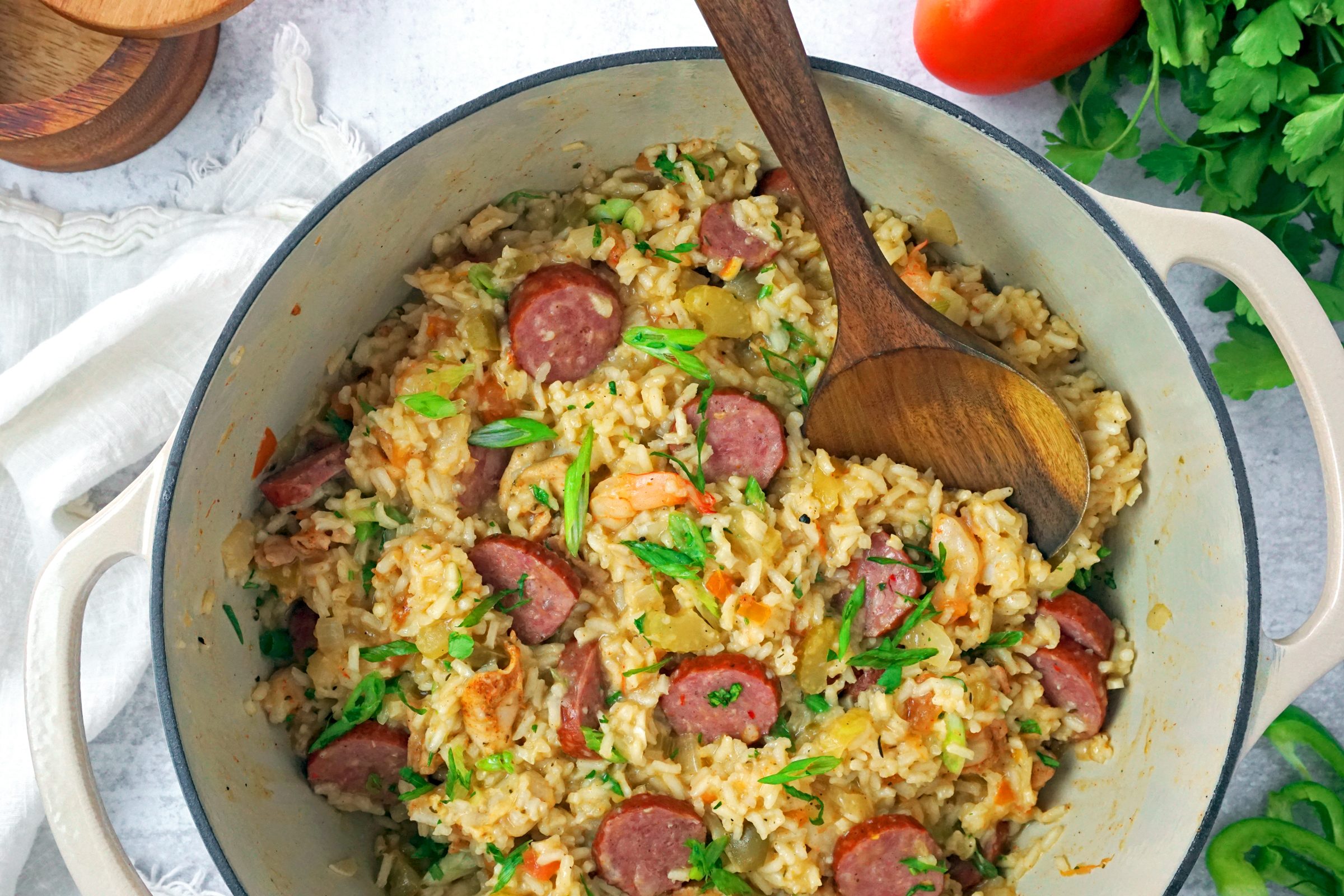 Jambalaya in a dutch oven pot with a wooden spoon