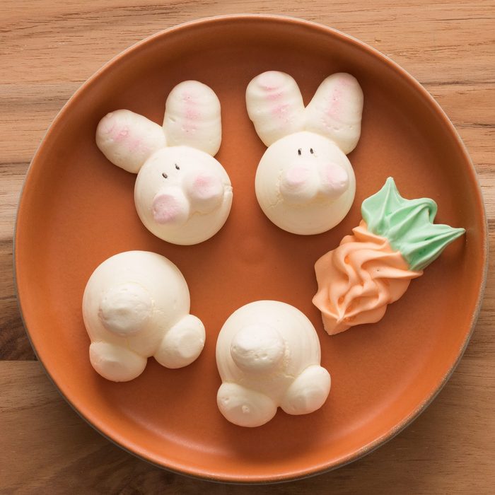 Adorable Easter Bunny and carrot Meringues on wood background