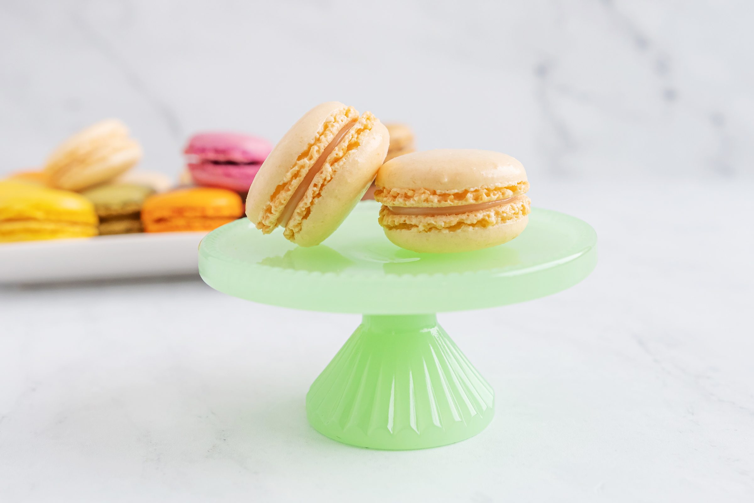 Coconut macaroon on a green plate with a stand