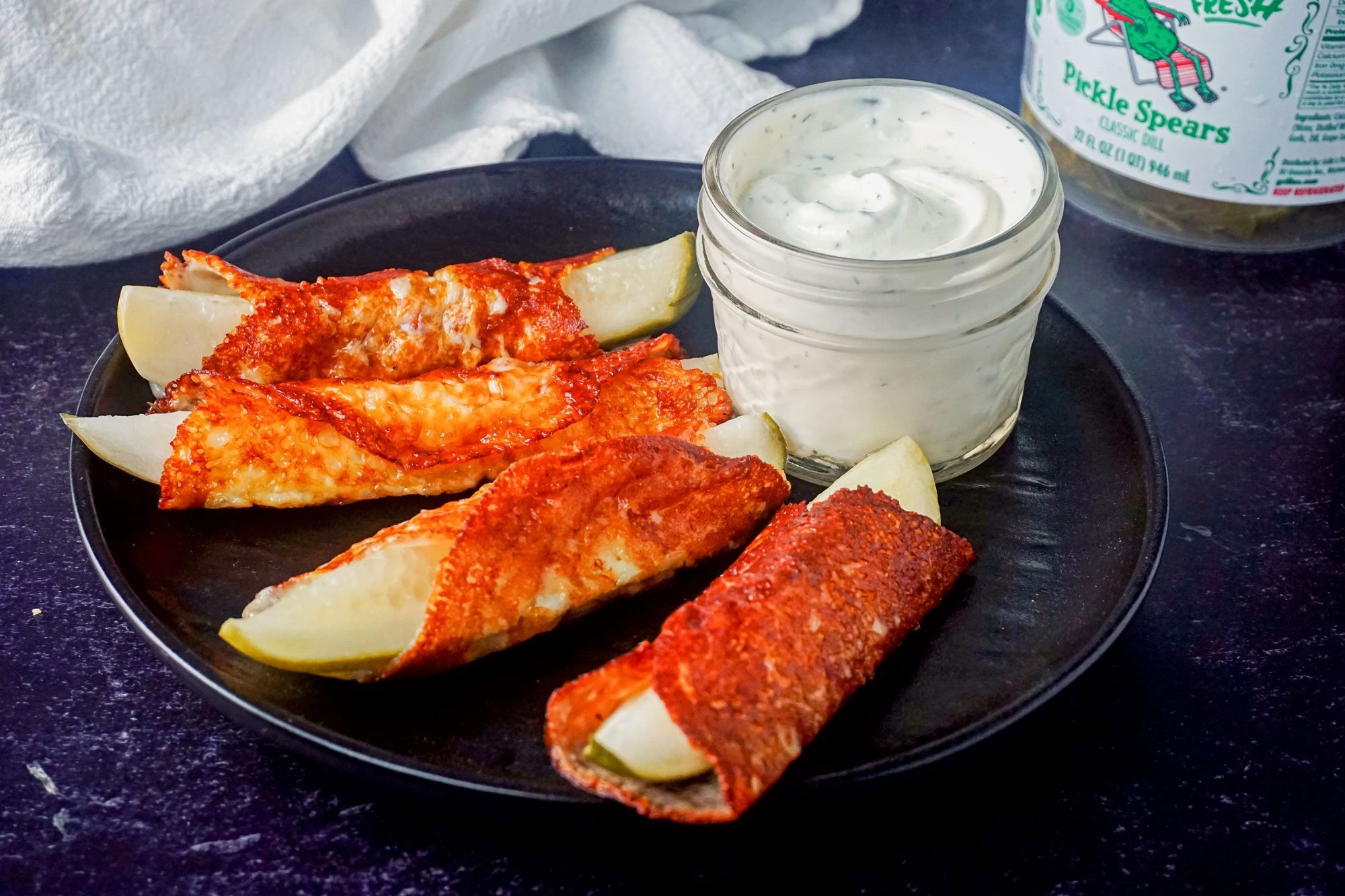 Cheese-Wrapped Pickles in Plate with Ranch Dressing