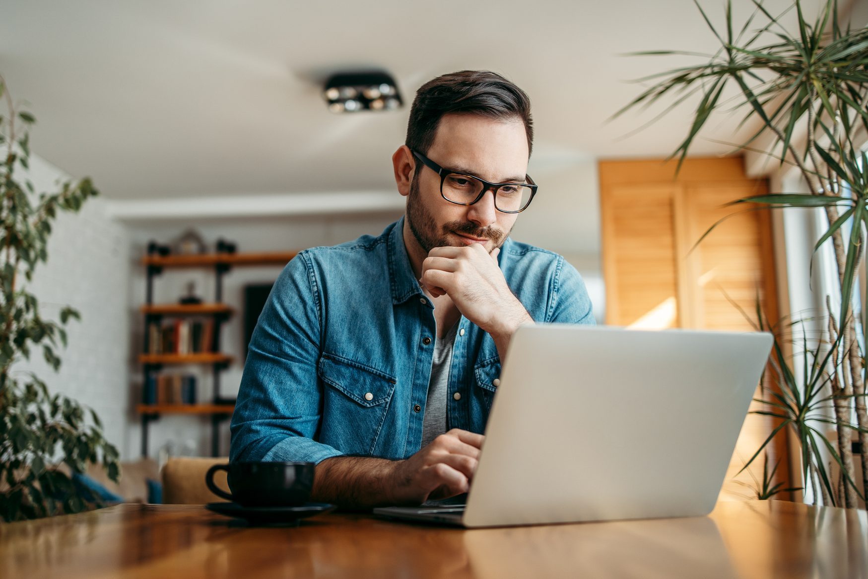 Portrait of a handsome man using laptop at home.