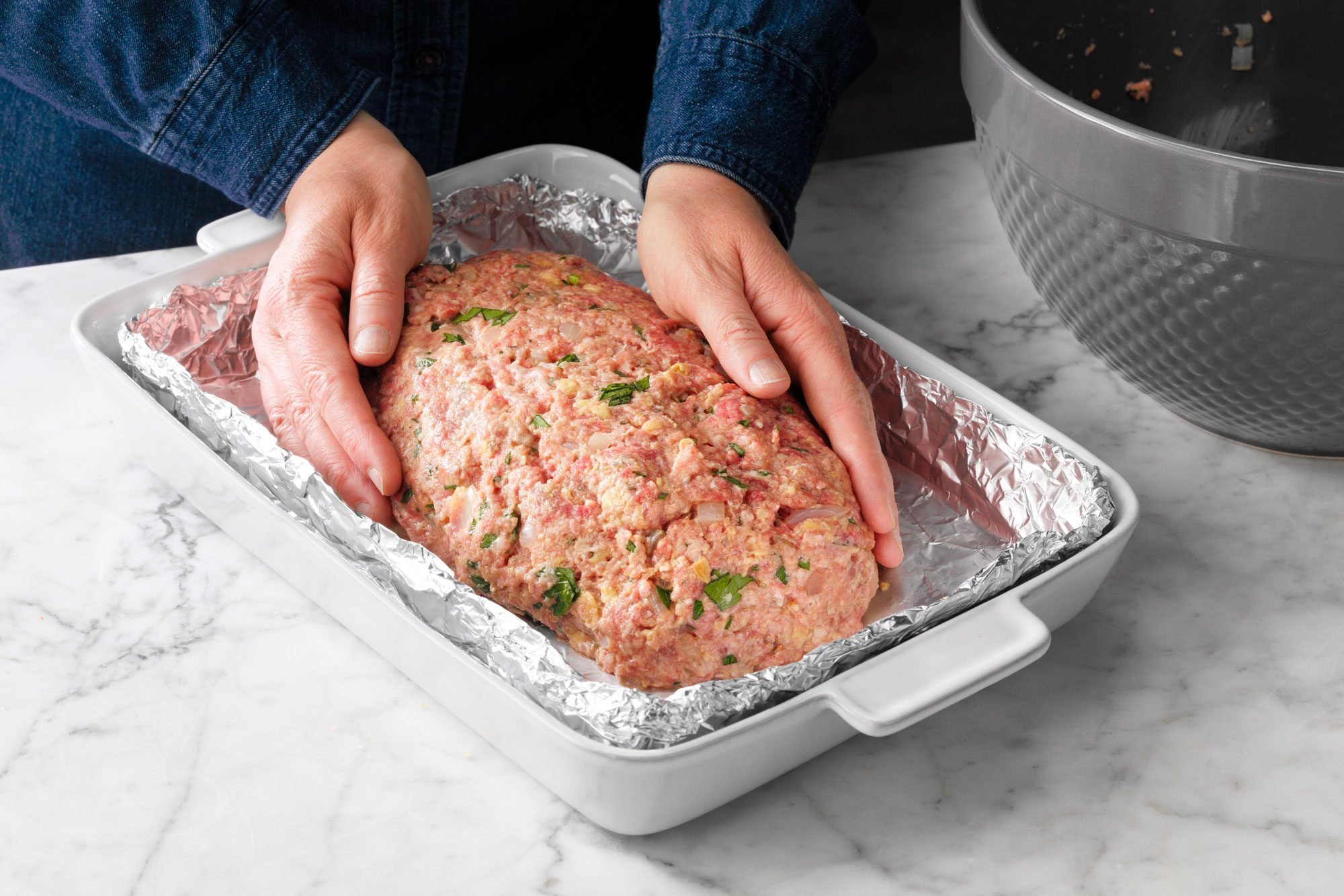 Bacon Wrapped Meat Loaf meat mixture being formed into a loaf in a foil lined pan