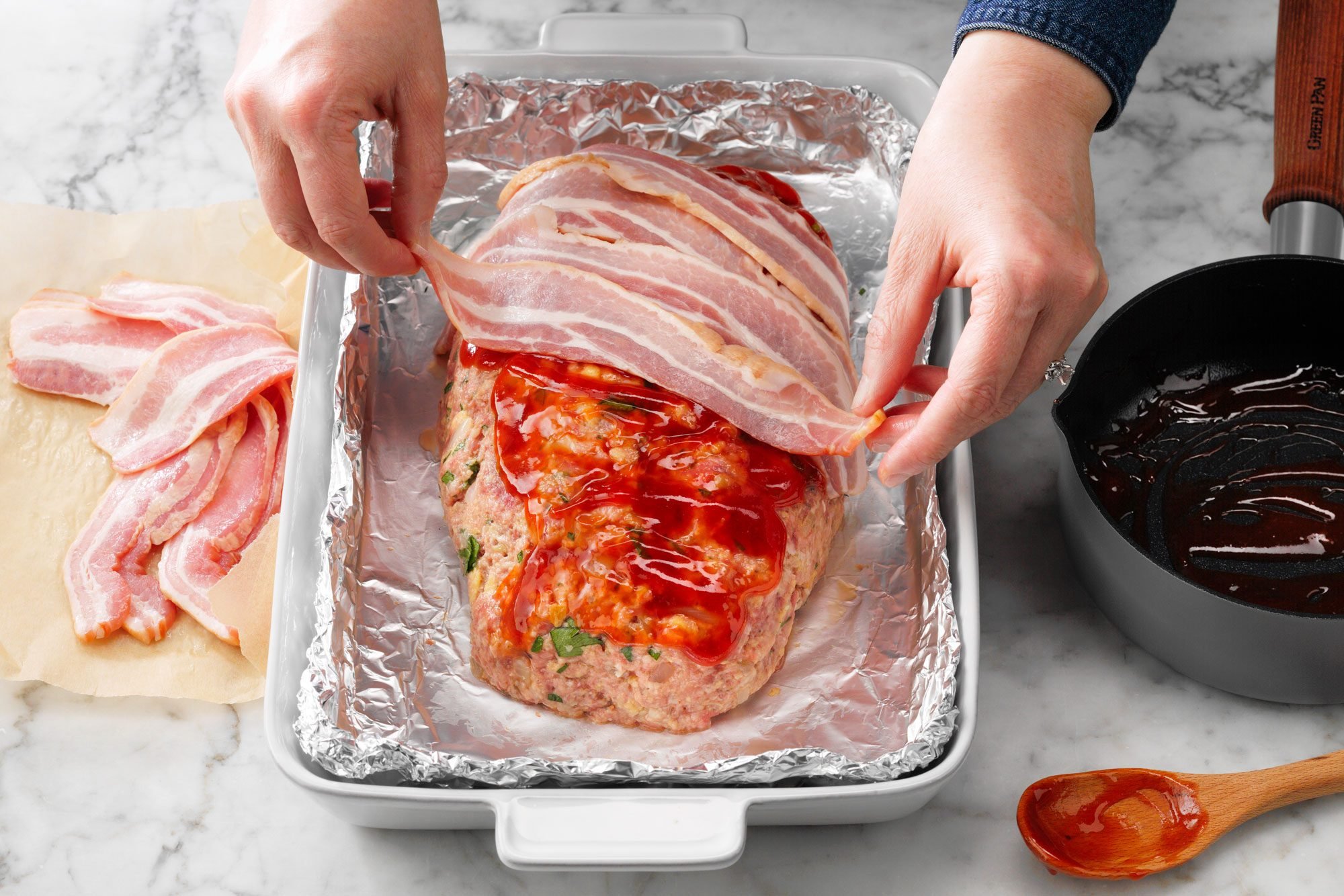 Bacon Wrapped Meat Loaf Showing Bacon Being Placed Over Meatloaf