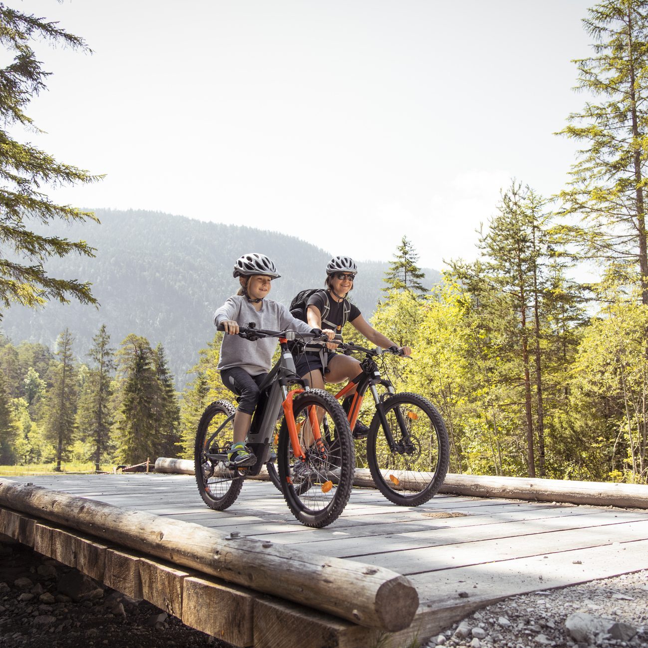 Mother and daughter riding e-mountain bikes in the mountains