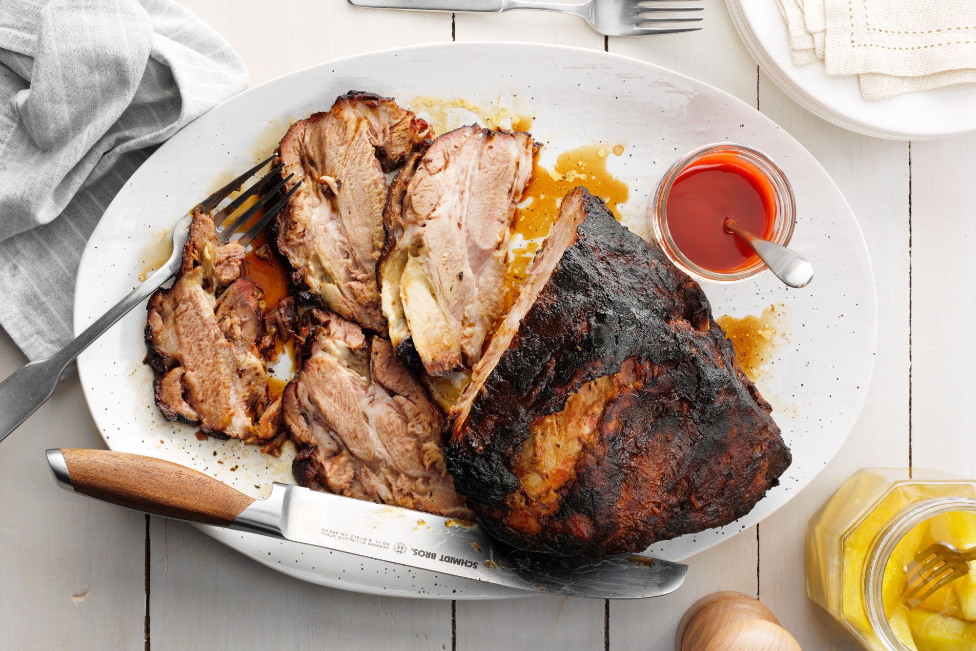 Taste Of Home's Smoked Pork Butt on a white serving platter with some slices cut