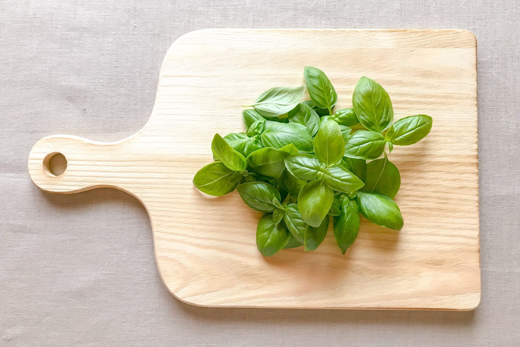 Fresh sweet basil o na wooden cutting board