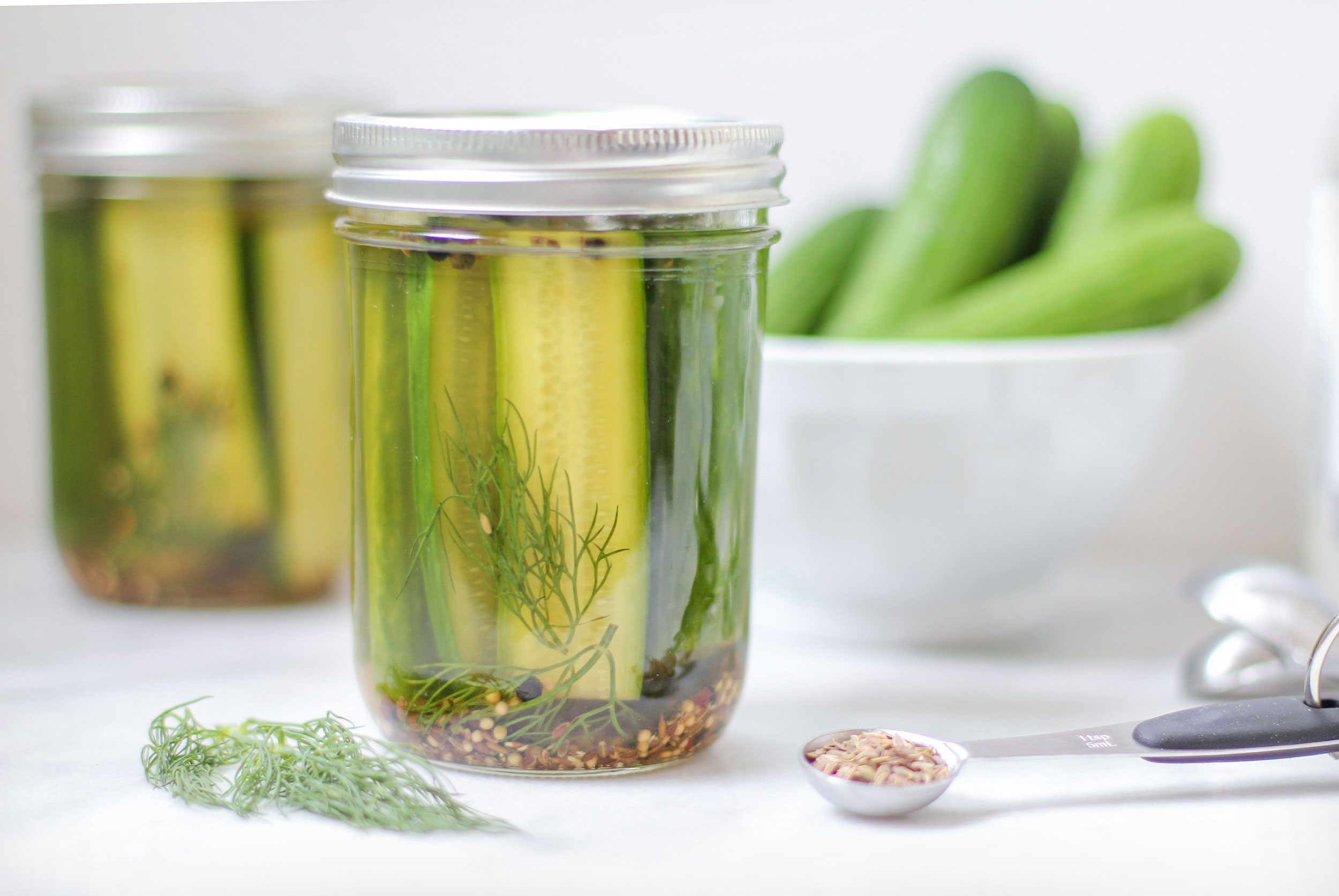 Pickled moonshine in a glass jar on a white top