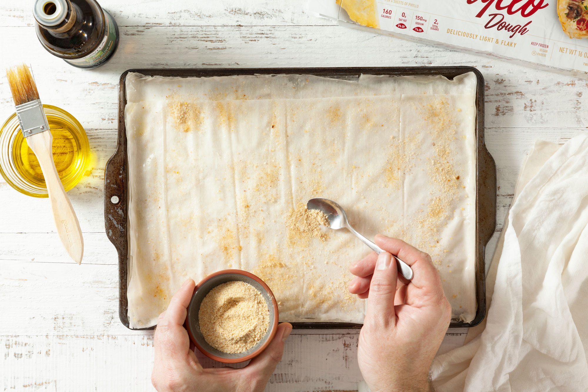 Start brushing phyllo sheet with oil and bread crumbs