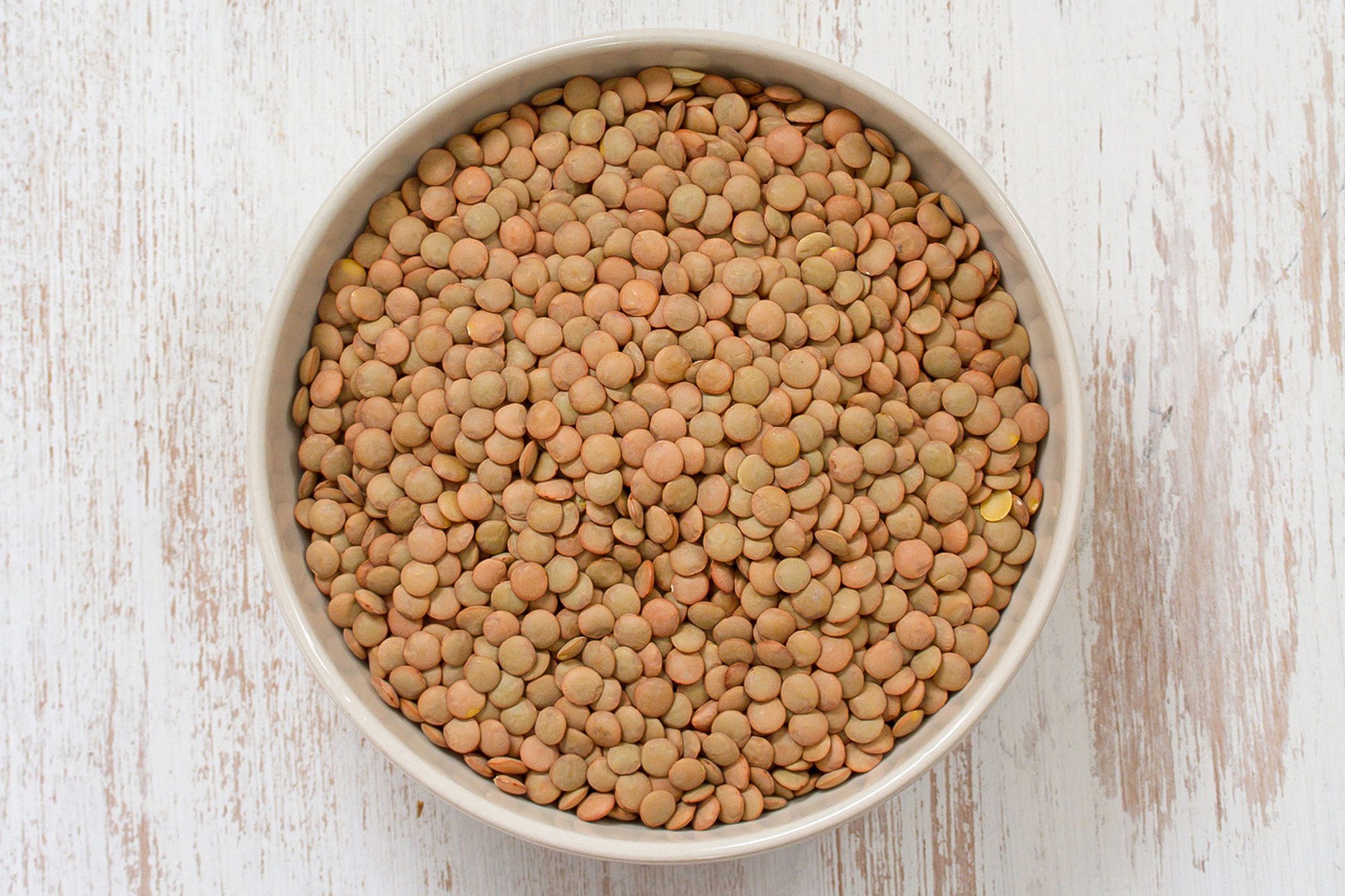 Brown Lentil Seeds In Bowl On White Painted Wooden Surface