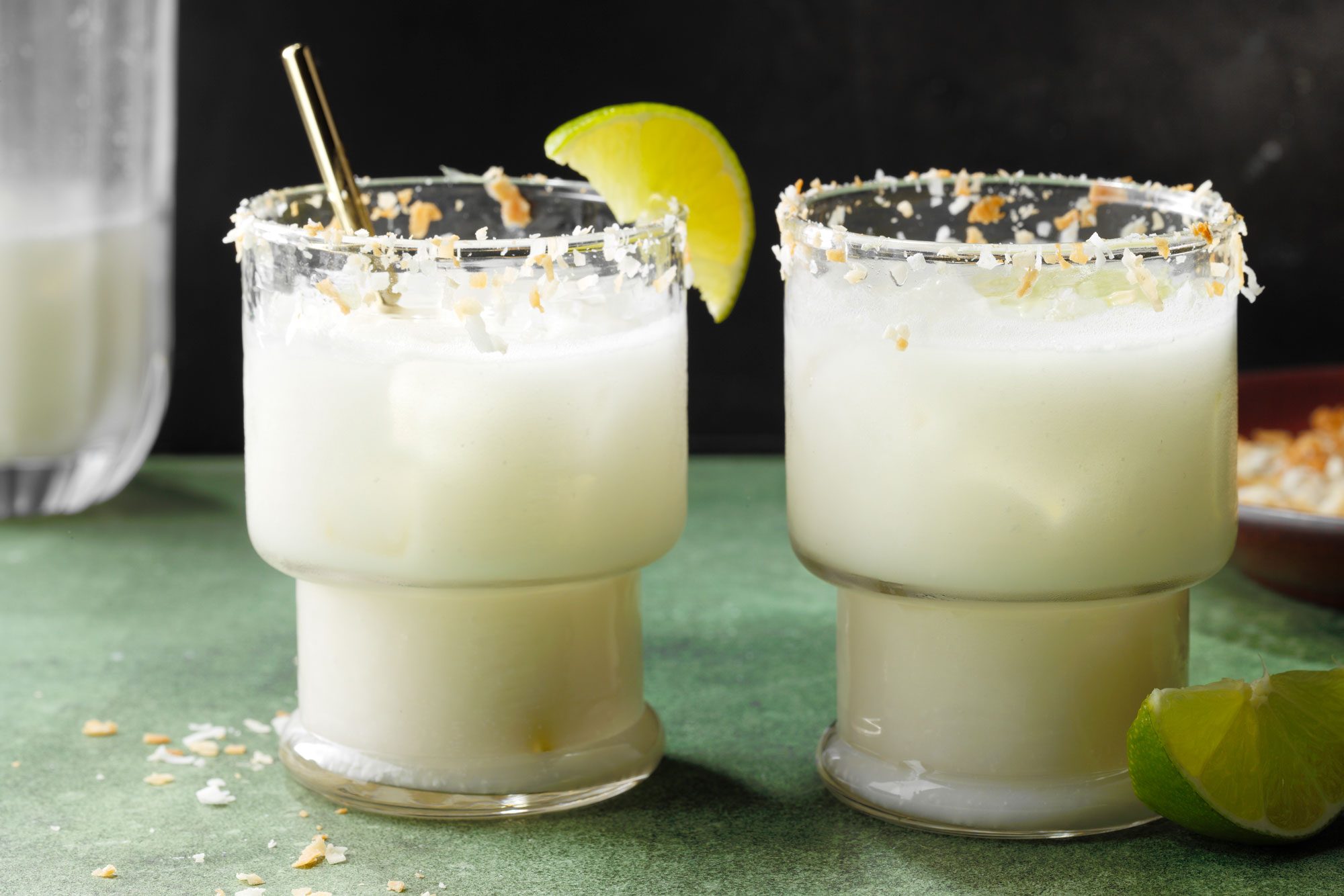 Coconut Margarita on the rocks in short glass with lemon on the side