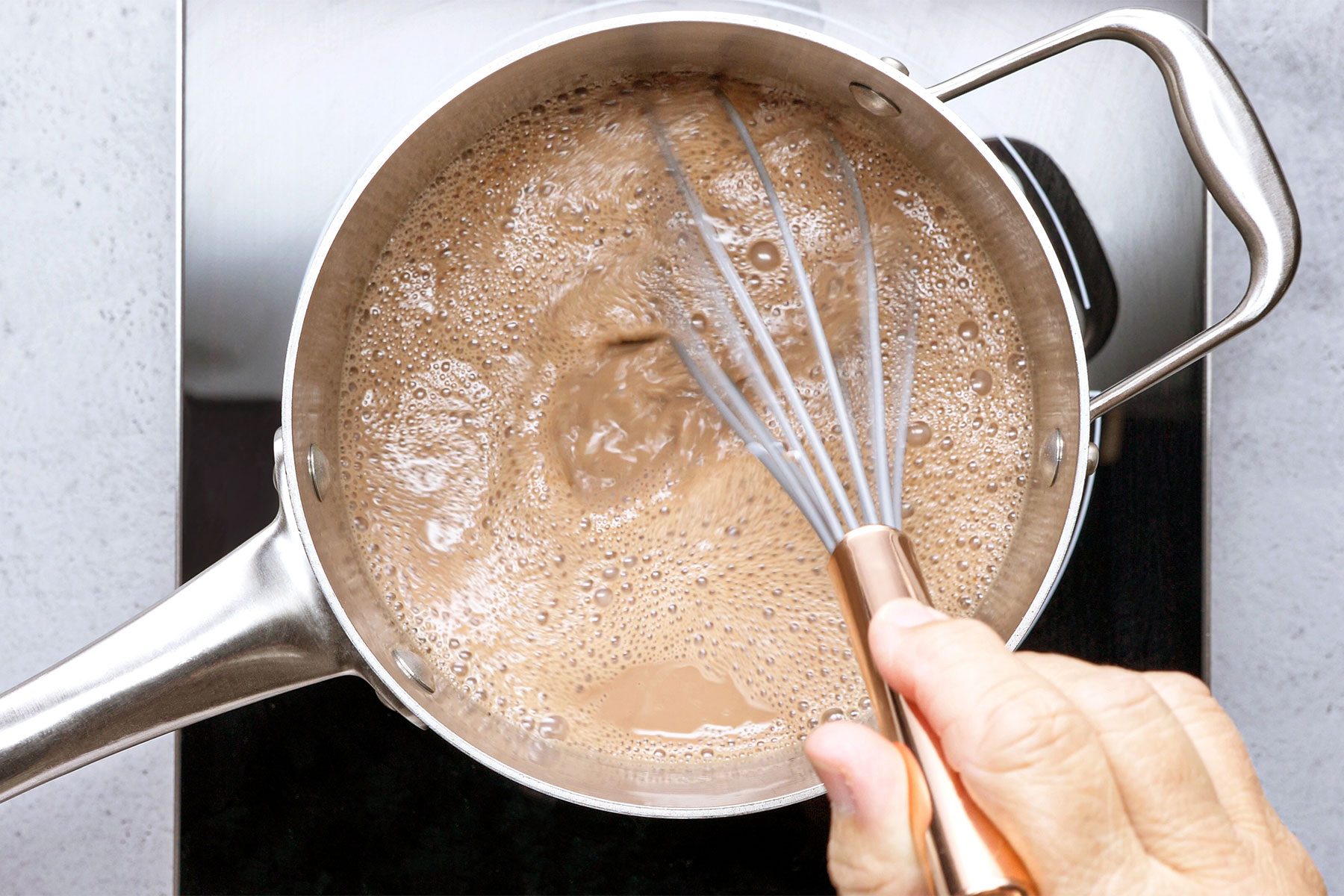 overhead shot of boiling hot cocoa in a saucepan