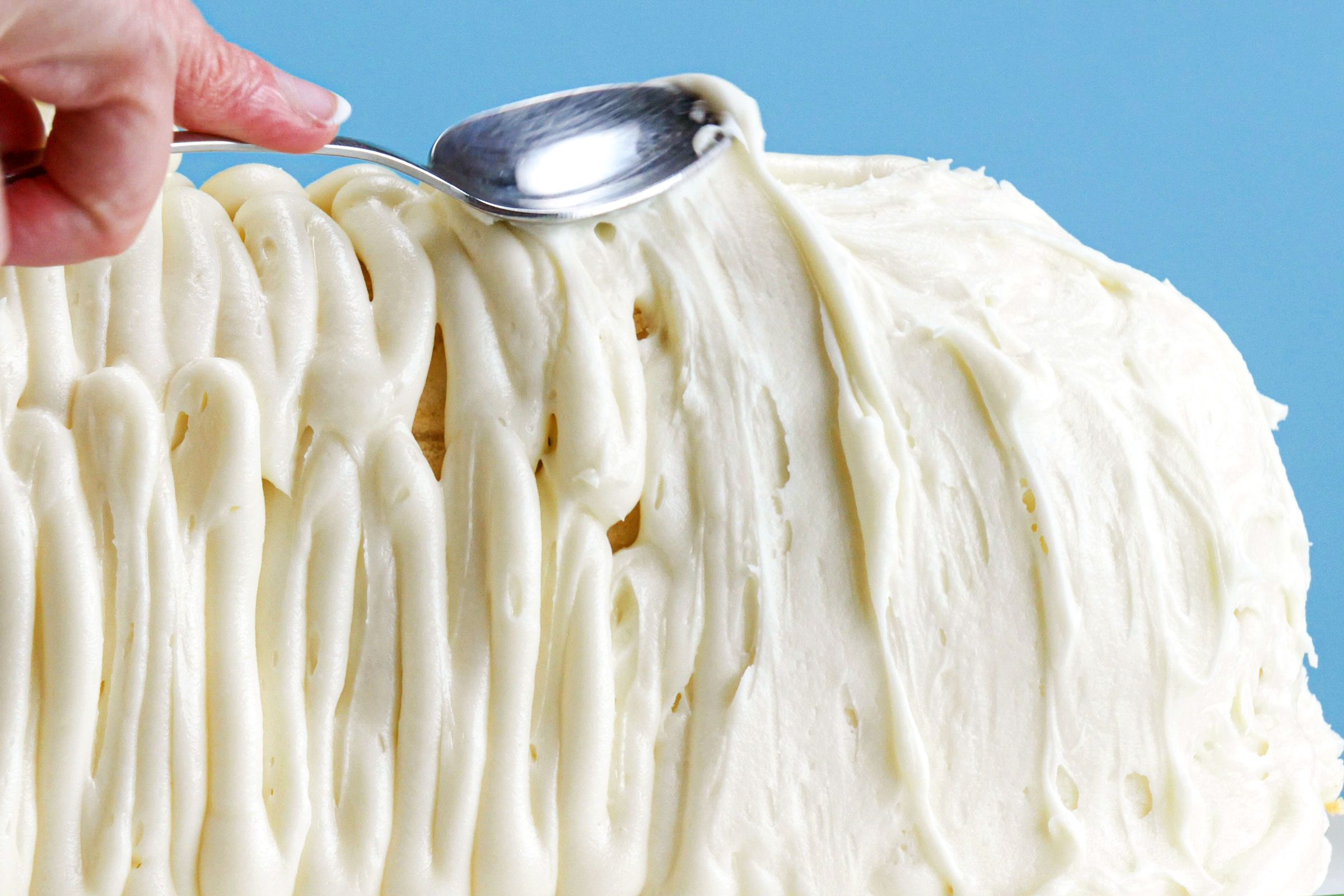 putting frosting on Easter Lamb Cake with a spoon close up 