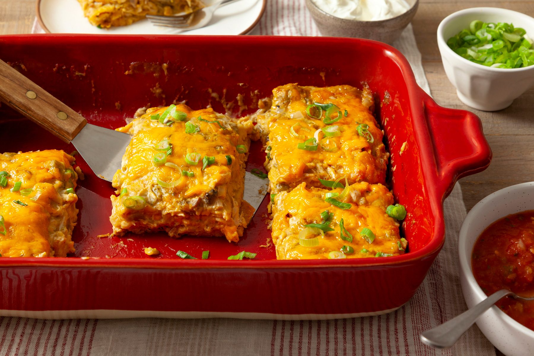 A red dish with chicken tortilla casserole in it