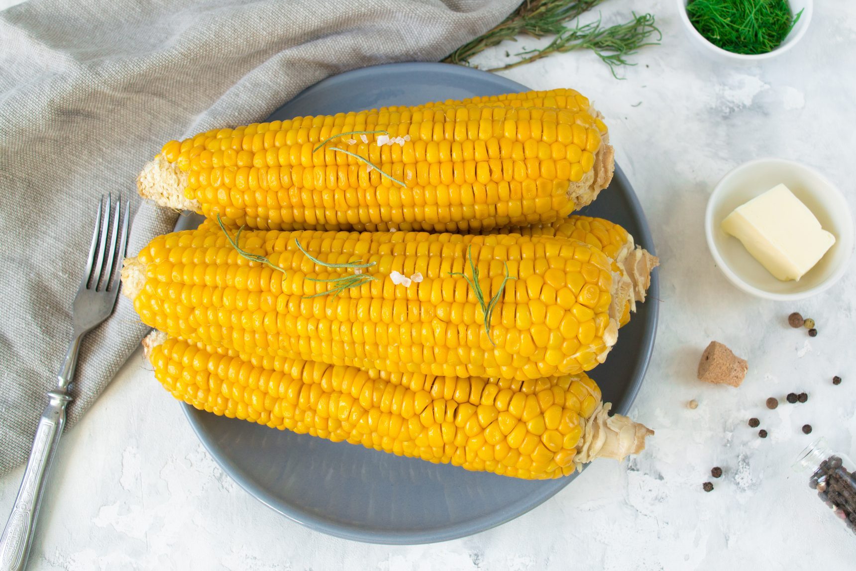 grilled corn, boiled corn on a wooden white plate. Vegetarian food, healthy food.