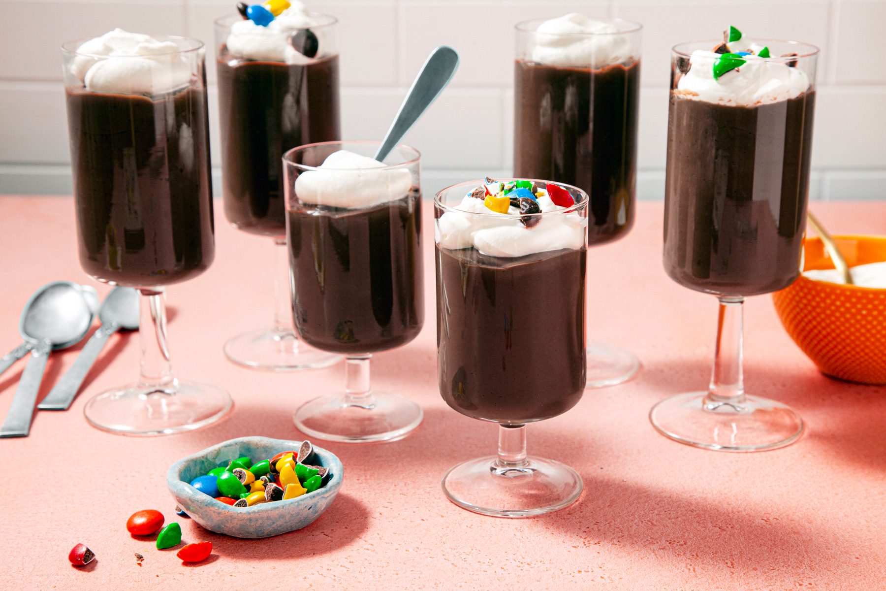 A group of glasses with homemade chocolate pudding and whipped cream