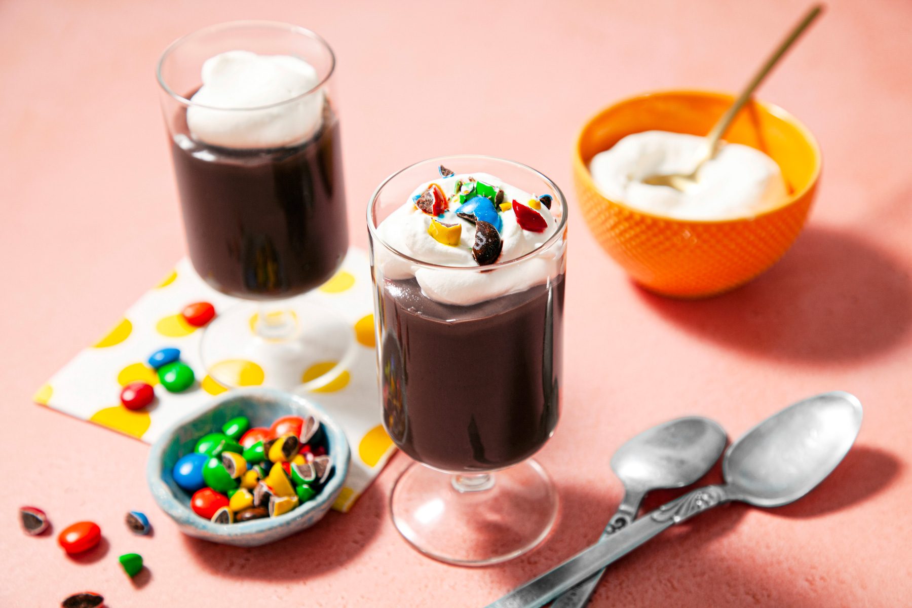 Two glasses of homemade chocolate pudding with whipped cream and candy