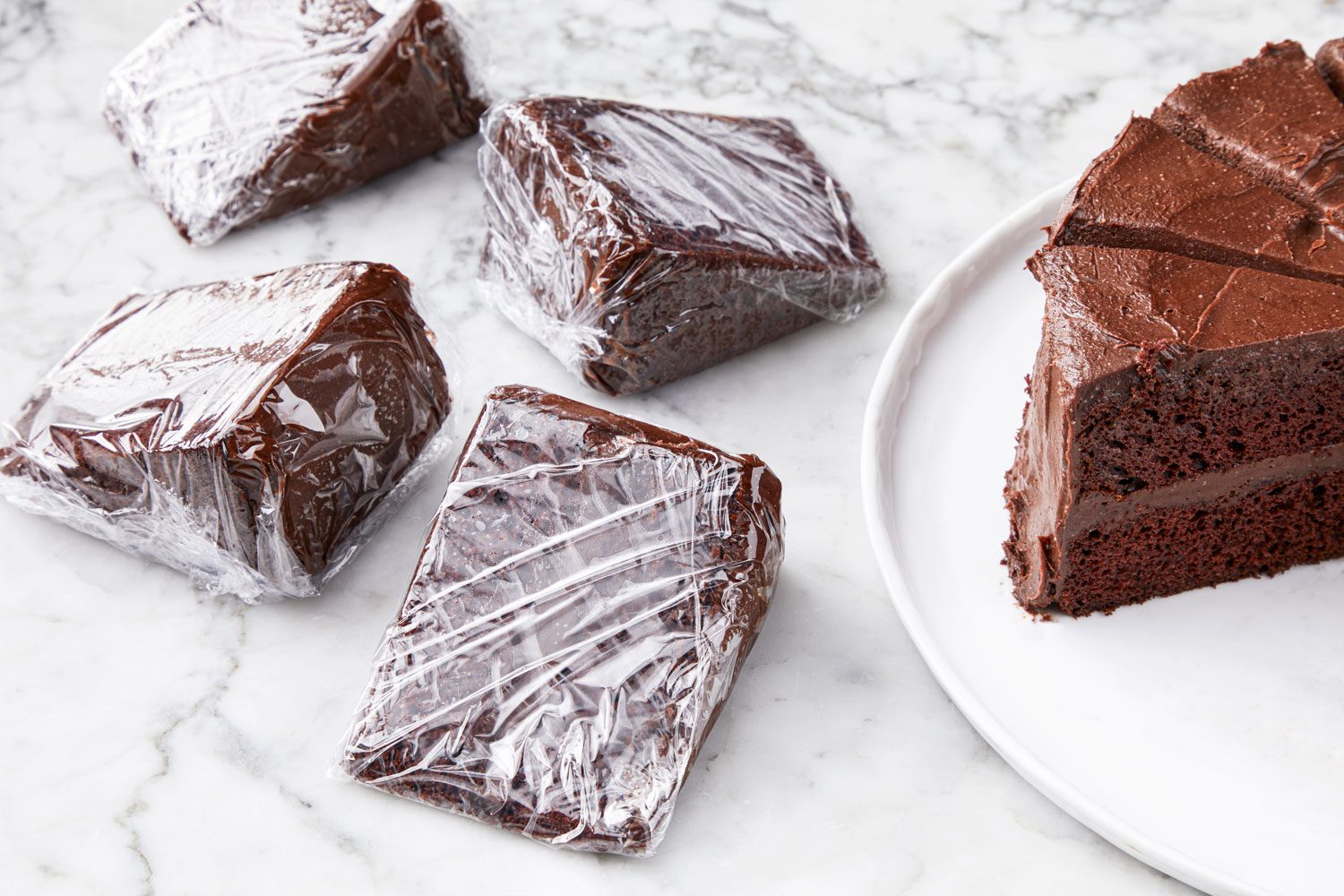 high angle view of cake slices wrapped in plastic for freezing.