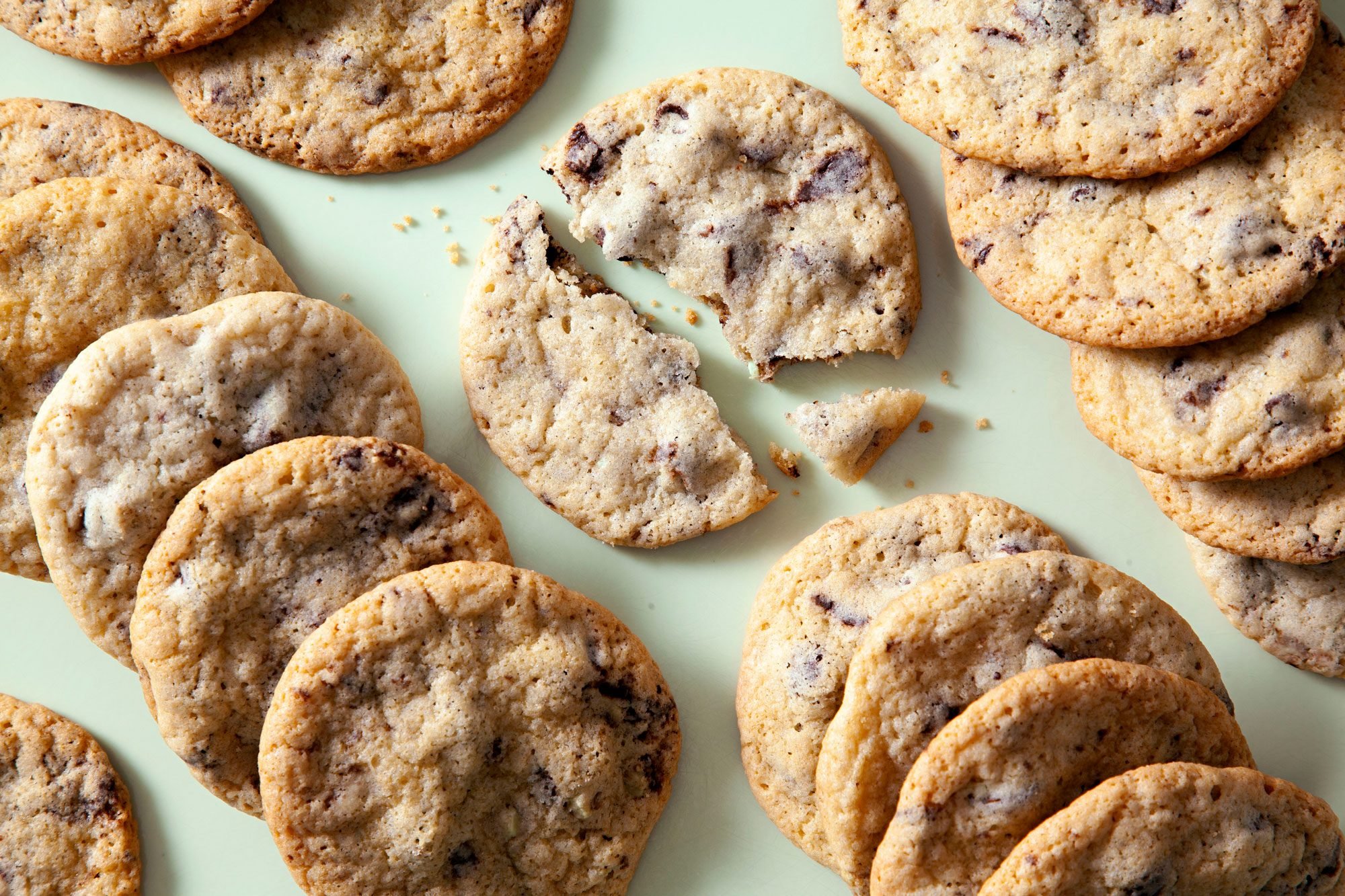 A lot of Mint Chocolate Chip Cookies on a Light Green Surface.