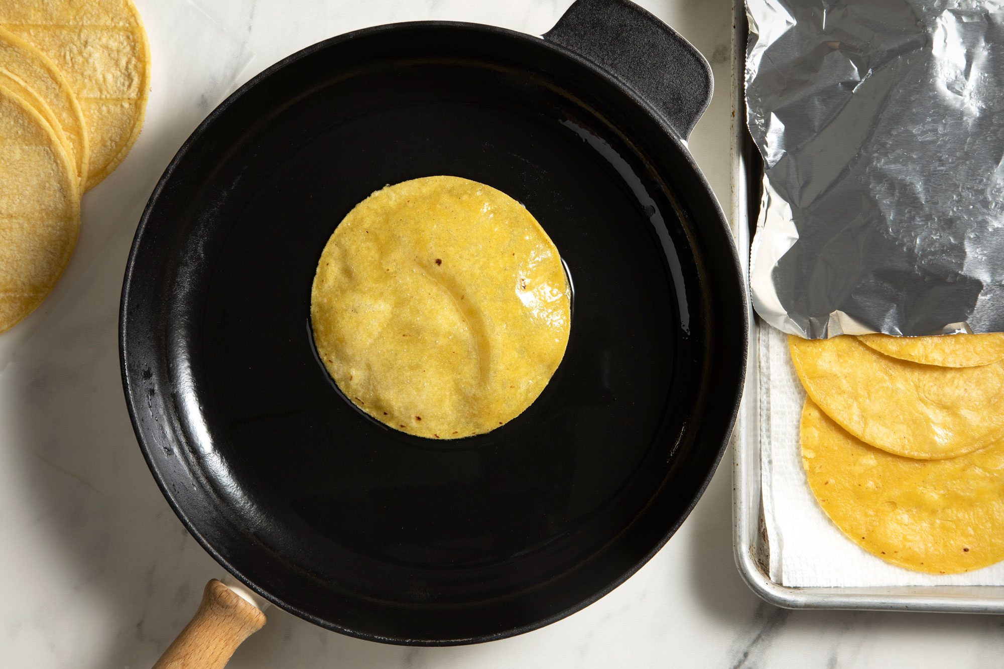 overhead shot; white background; In a skillet fry tortillas;
