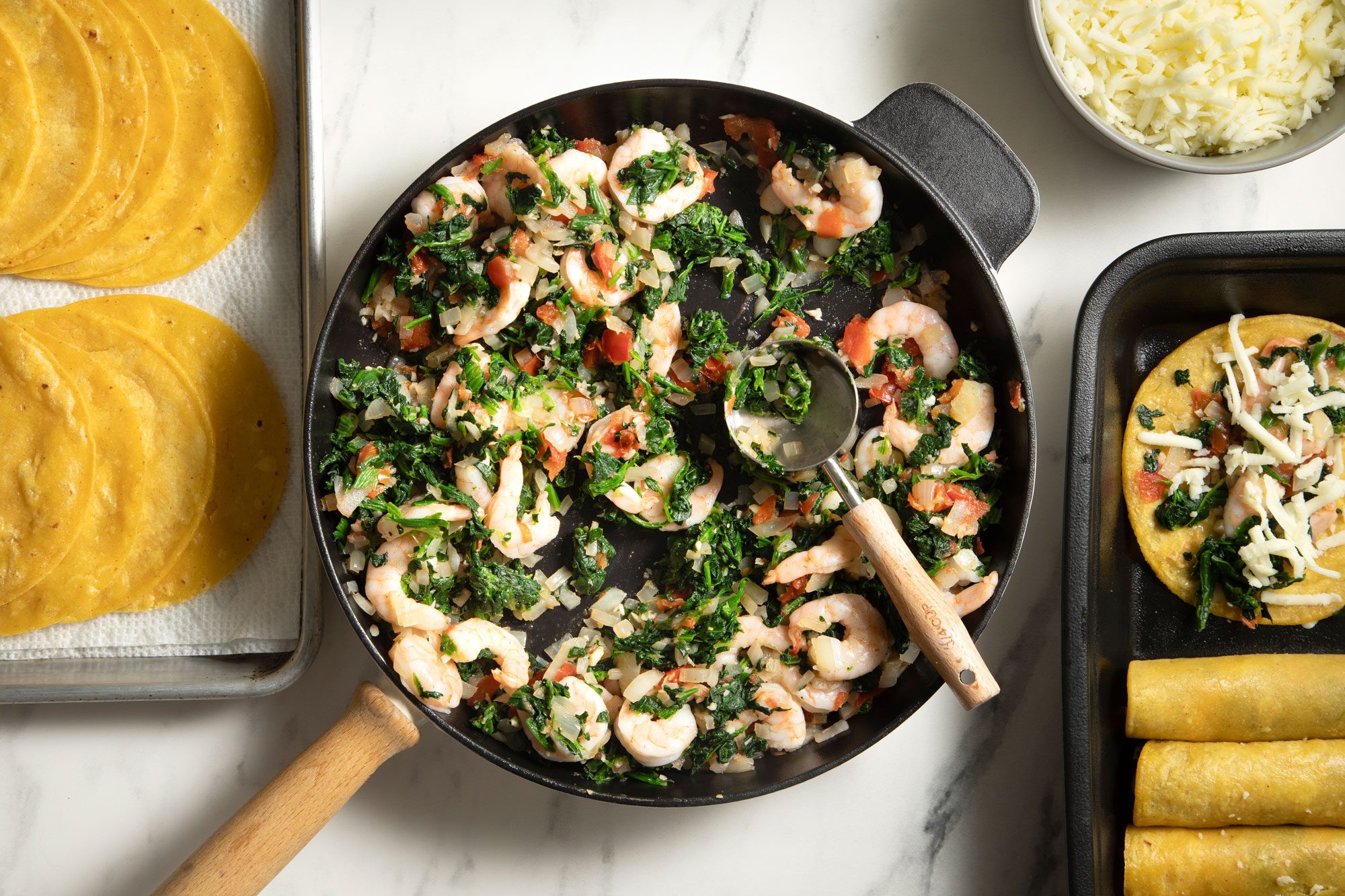 overhead shot; white background; In a large skillet, Add tomatoes, onions, garlic and cumin; cook and stir until onions are tender; Add shrimp; add spinach;