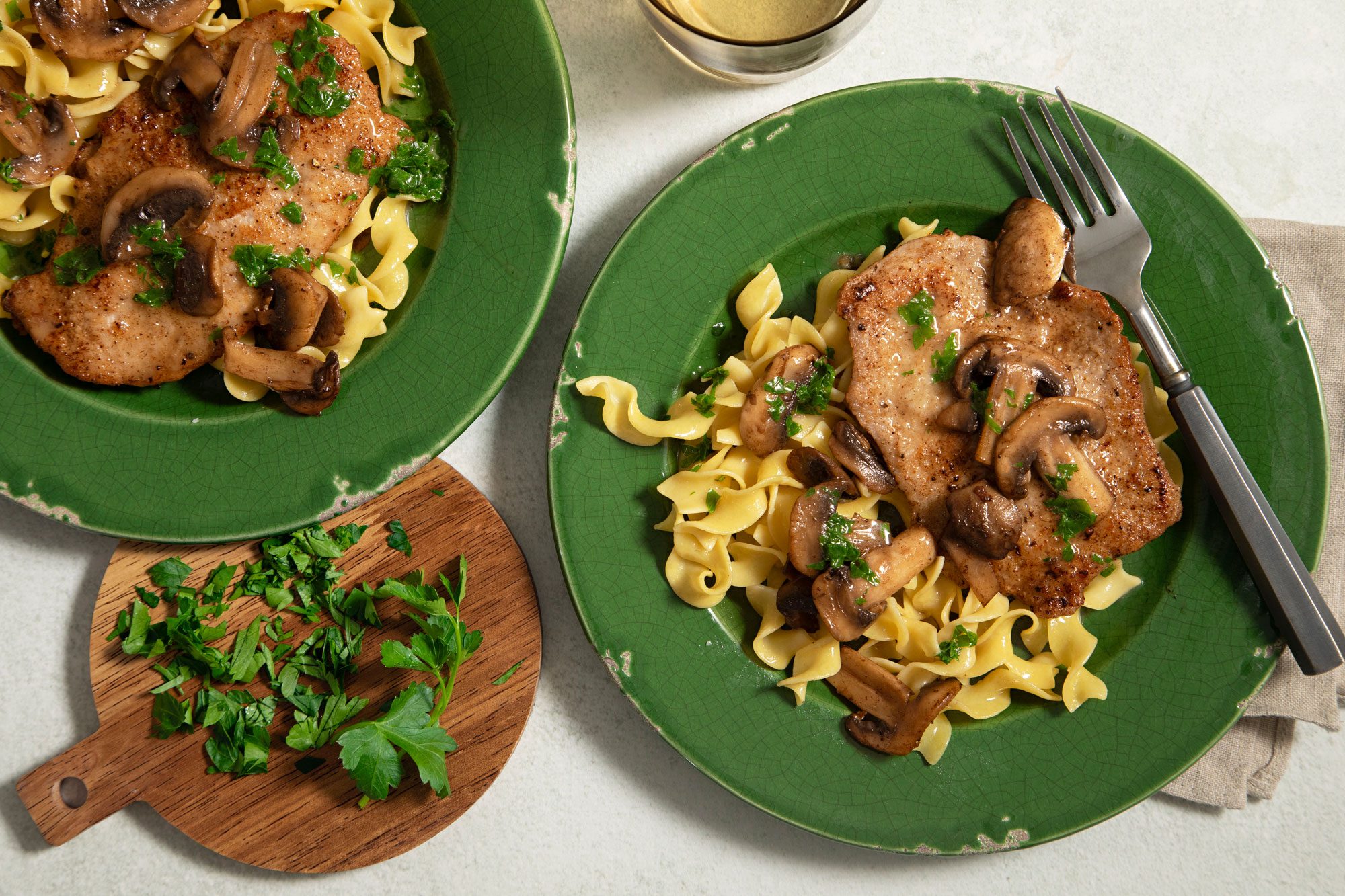 Veal Scallopini Served on a Green Ceramic Plate with a Fork