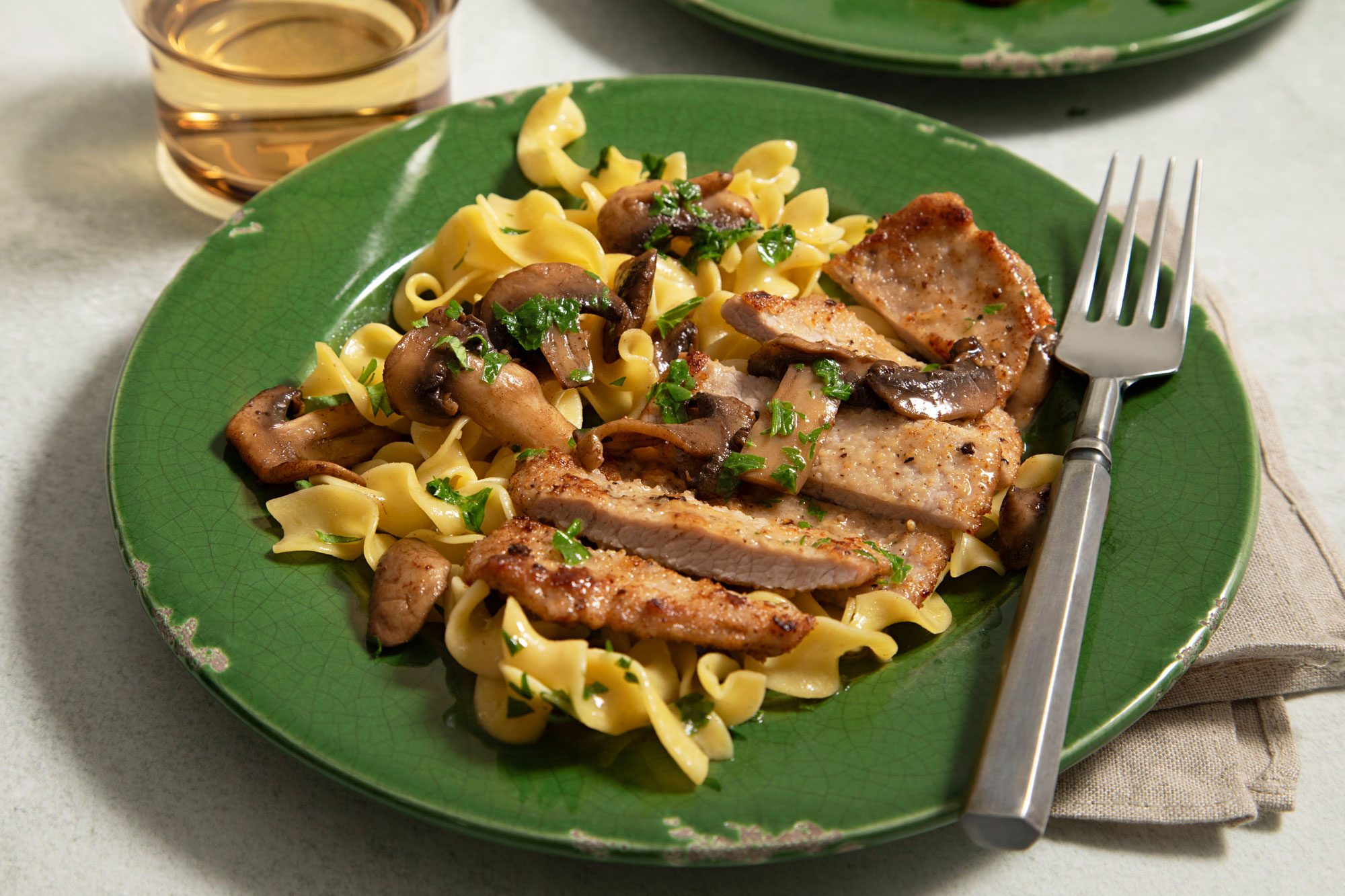 Veal Scallopini Served on a Green Ceramic Plate with a Fork