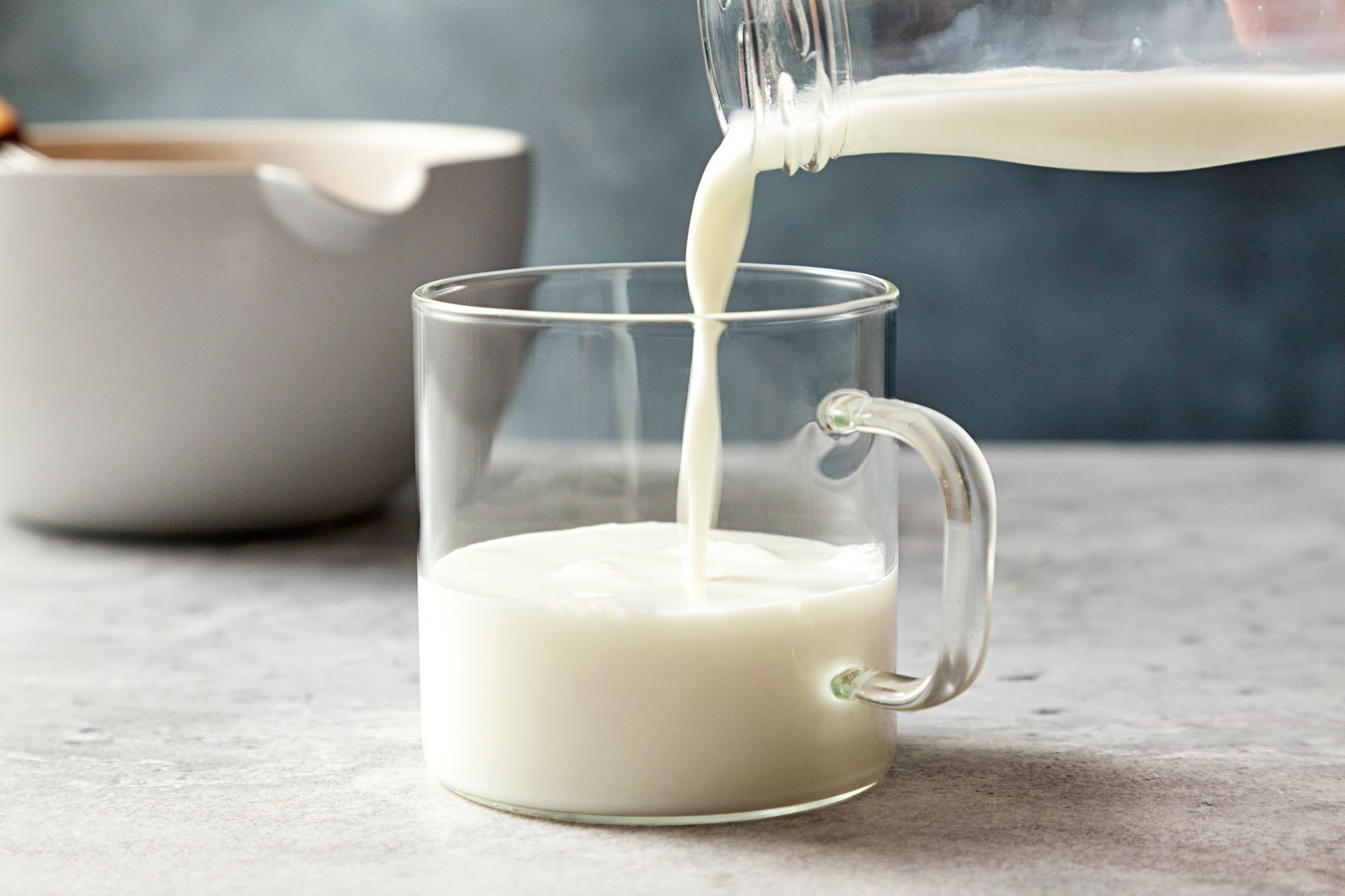 wide shot of pouring milk in a cup