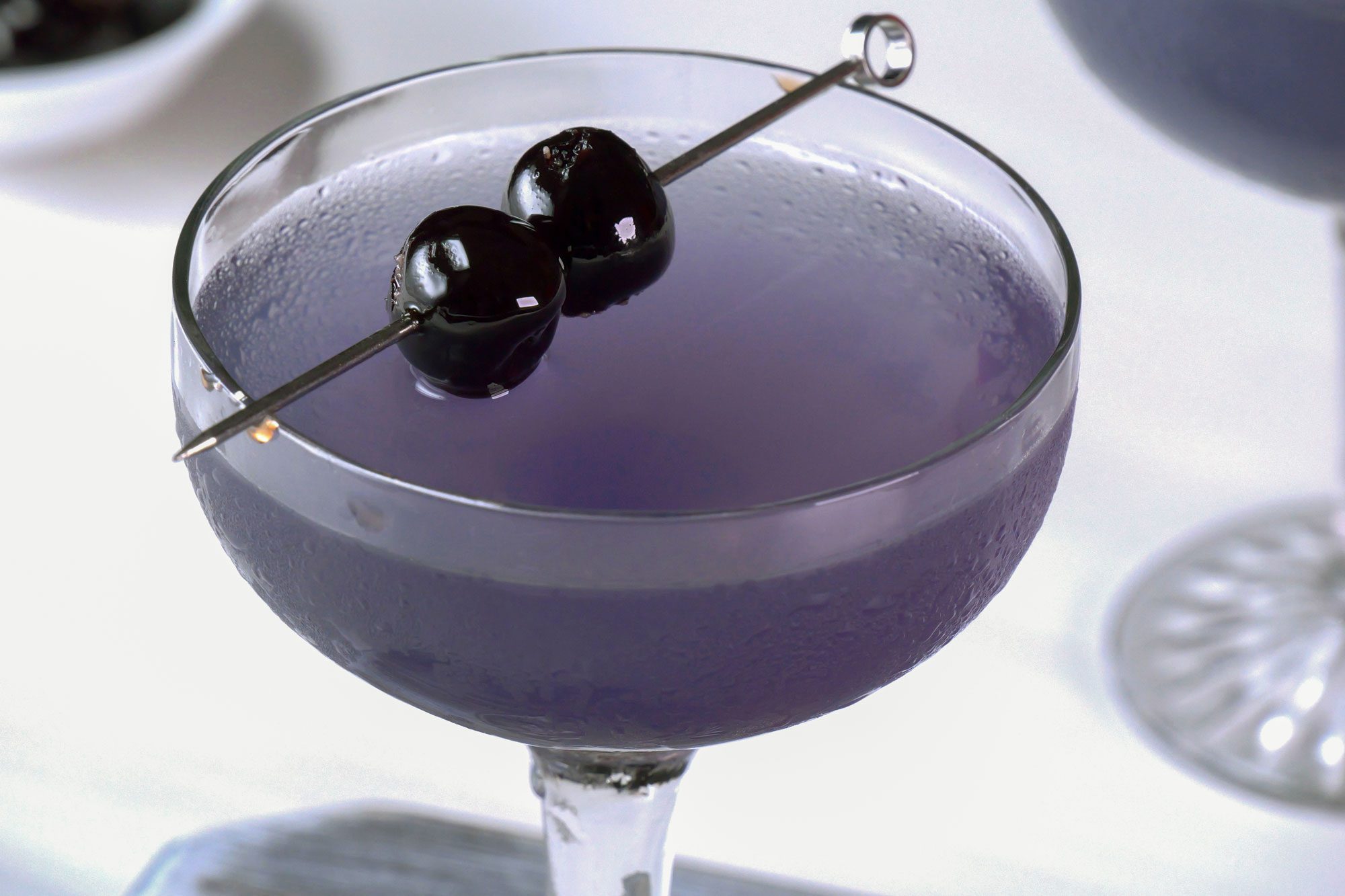 Aviation drink served in coupe glass, Garnished with cherries