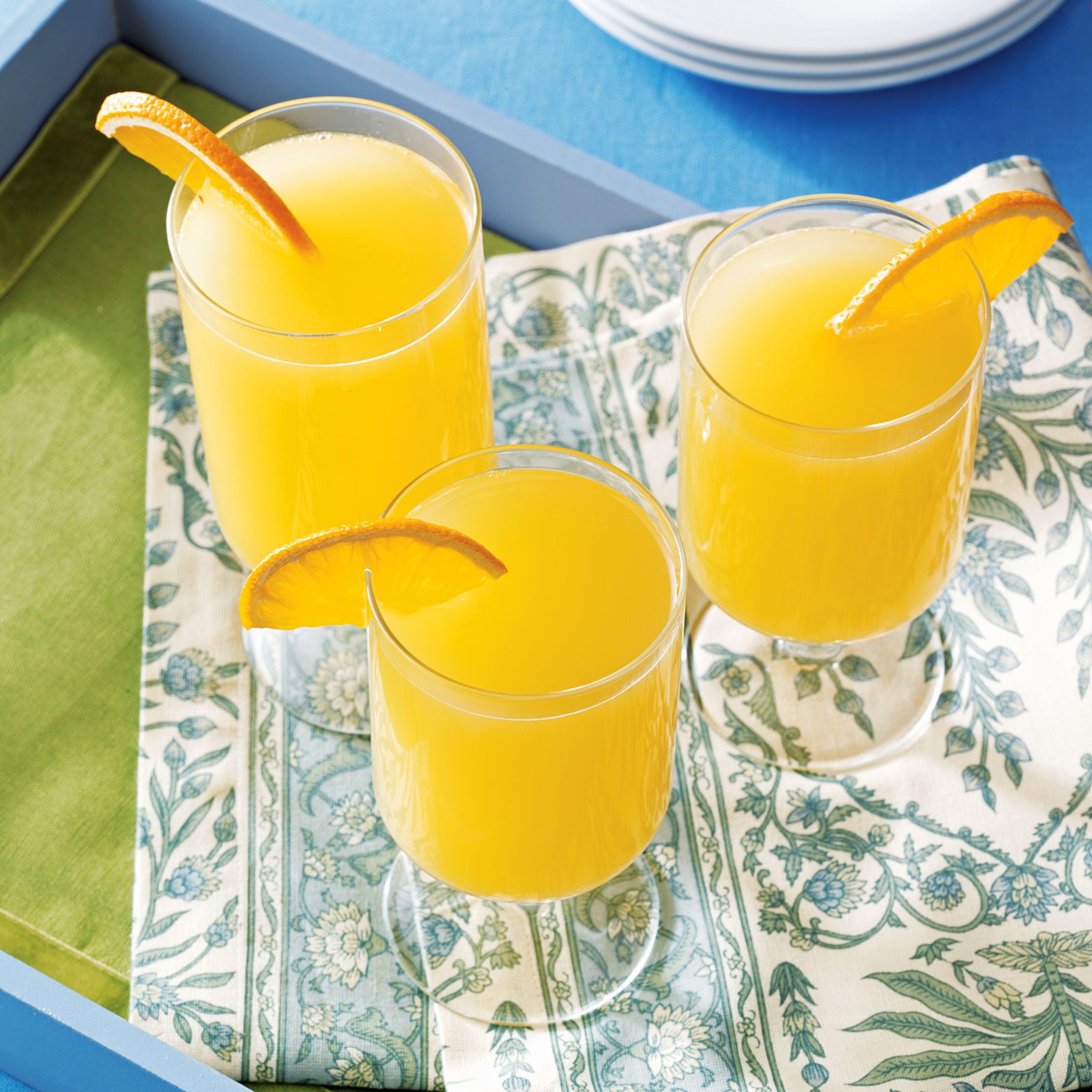 top view three mimosa glasses garnished with an orange slice on the side