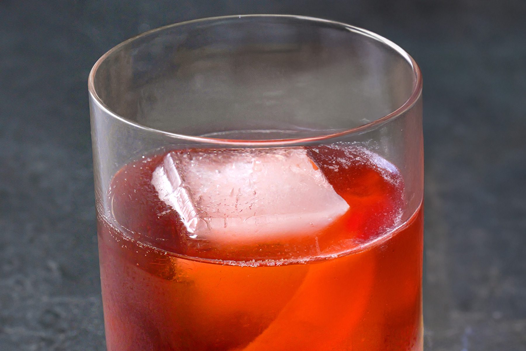 A glass of Boulevardier cocktail garnished with orange peel