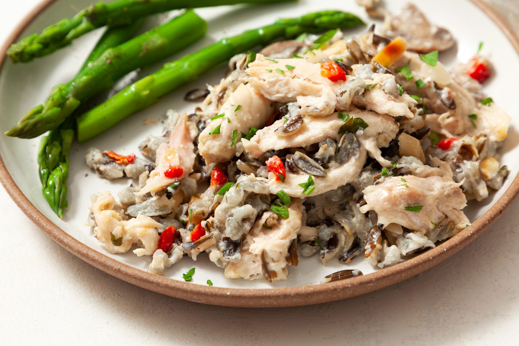A plate of chicken wild rice casserole served with asparagus