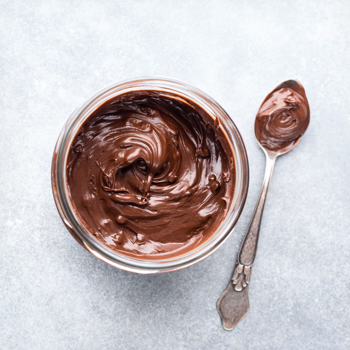 Chocolate Nut Butter Jar And Spoon On Concrete Table Background