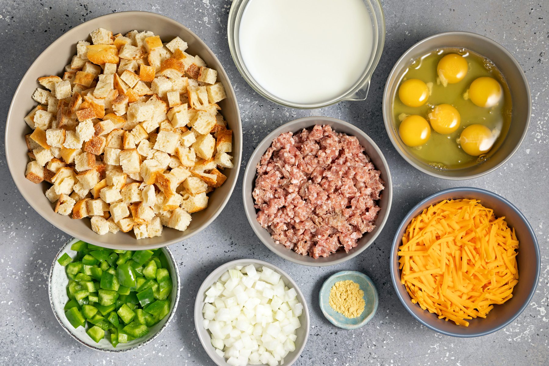 Bowls of bread, sausage, vegetables, and other ingredients