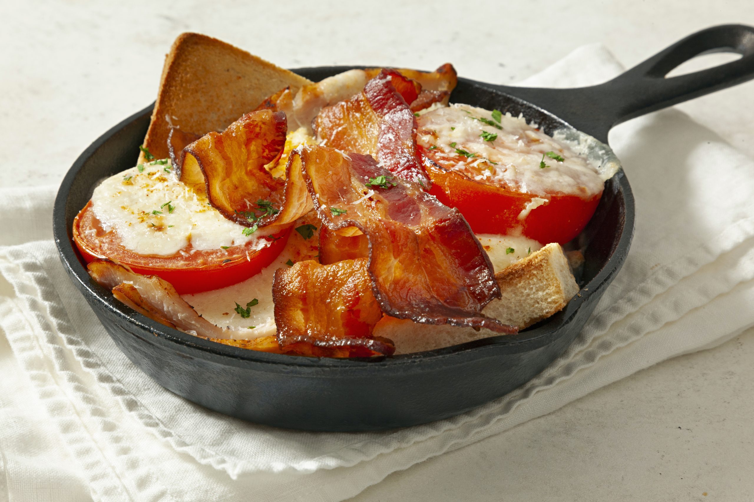 Kentucky Hot Brown served on black pan over kitchen towel