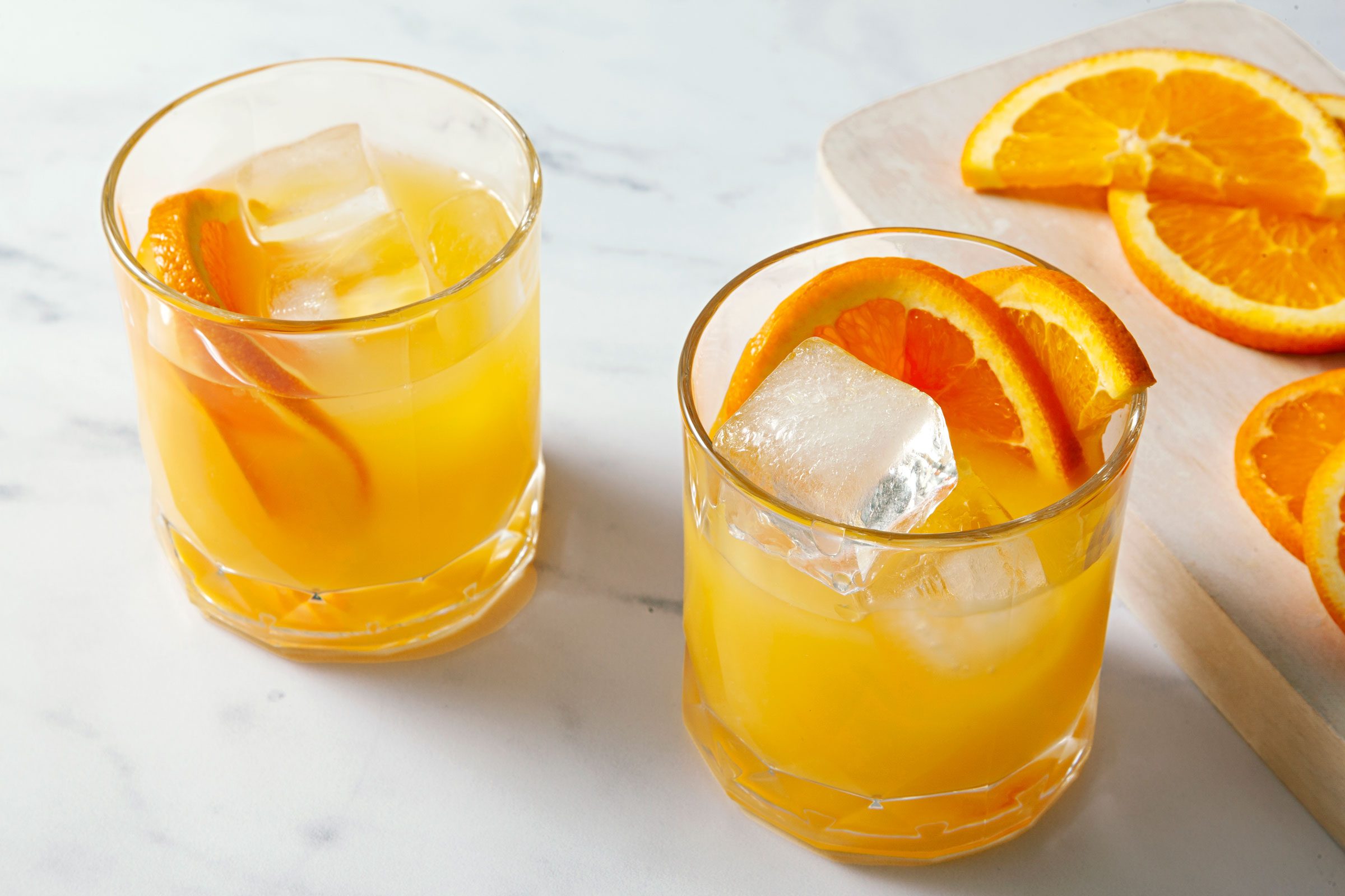 Two Screwdriver cocktail in glasses garnished with orange slices
