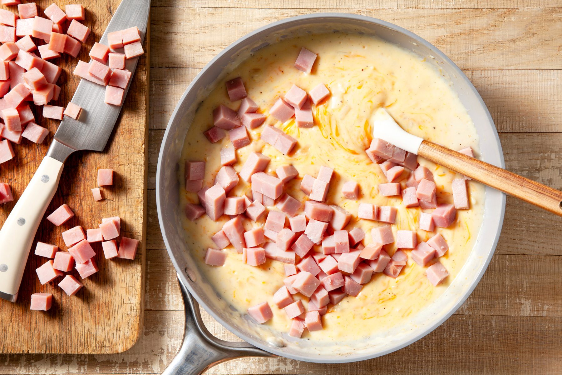 overhead shot of ham added in the cheese mixture