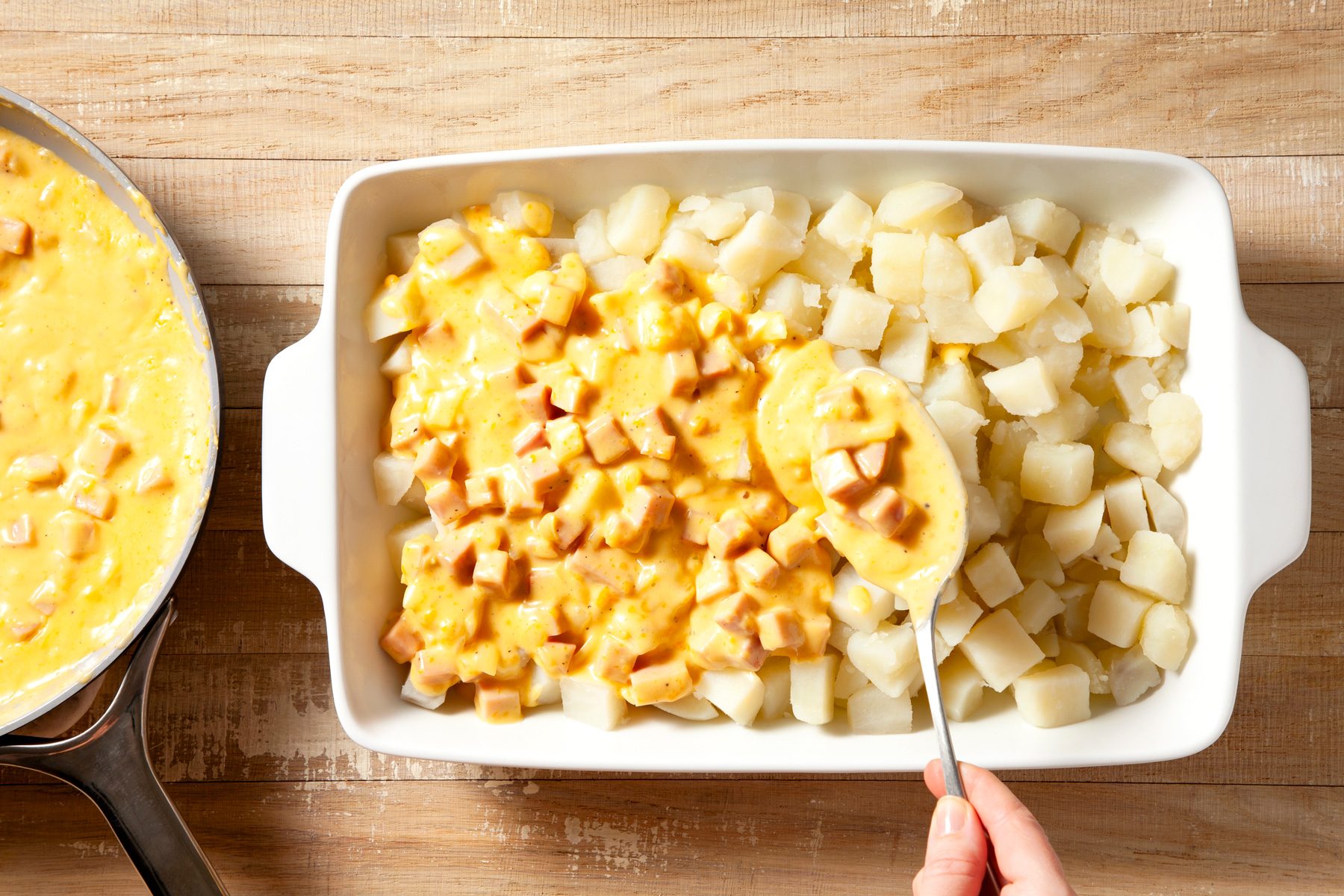 overhead shot of boiled potatoes topped with sauce in a large baking dish