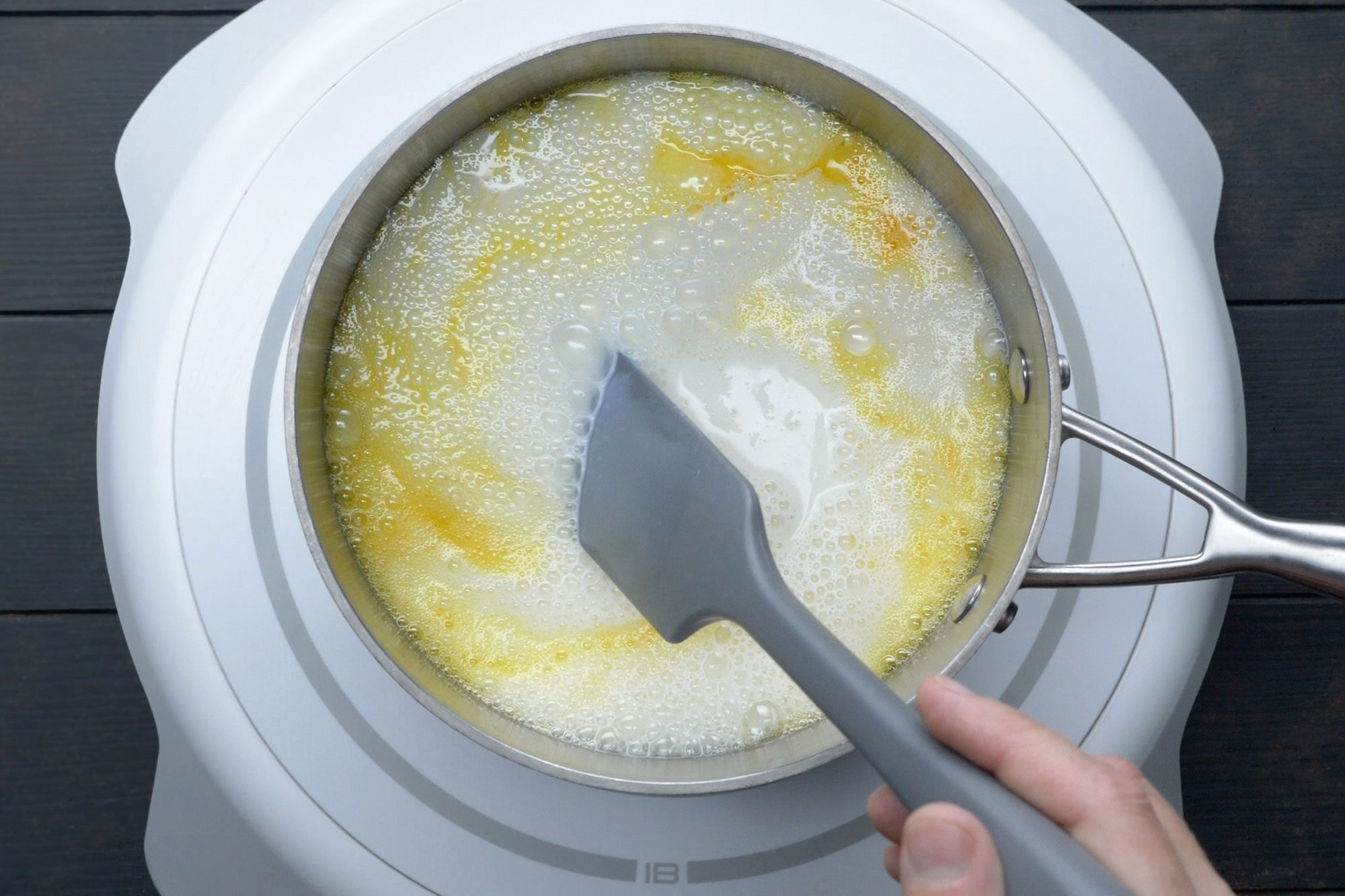 overhead shot of egg mixture whisked together in a saucepan