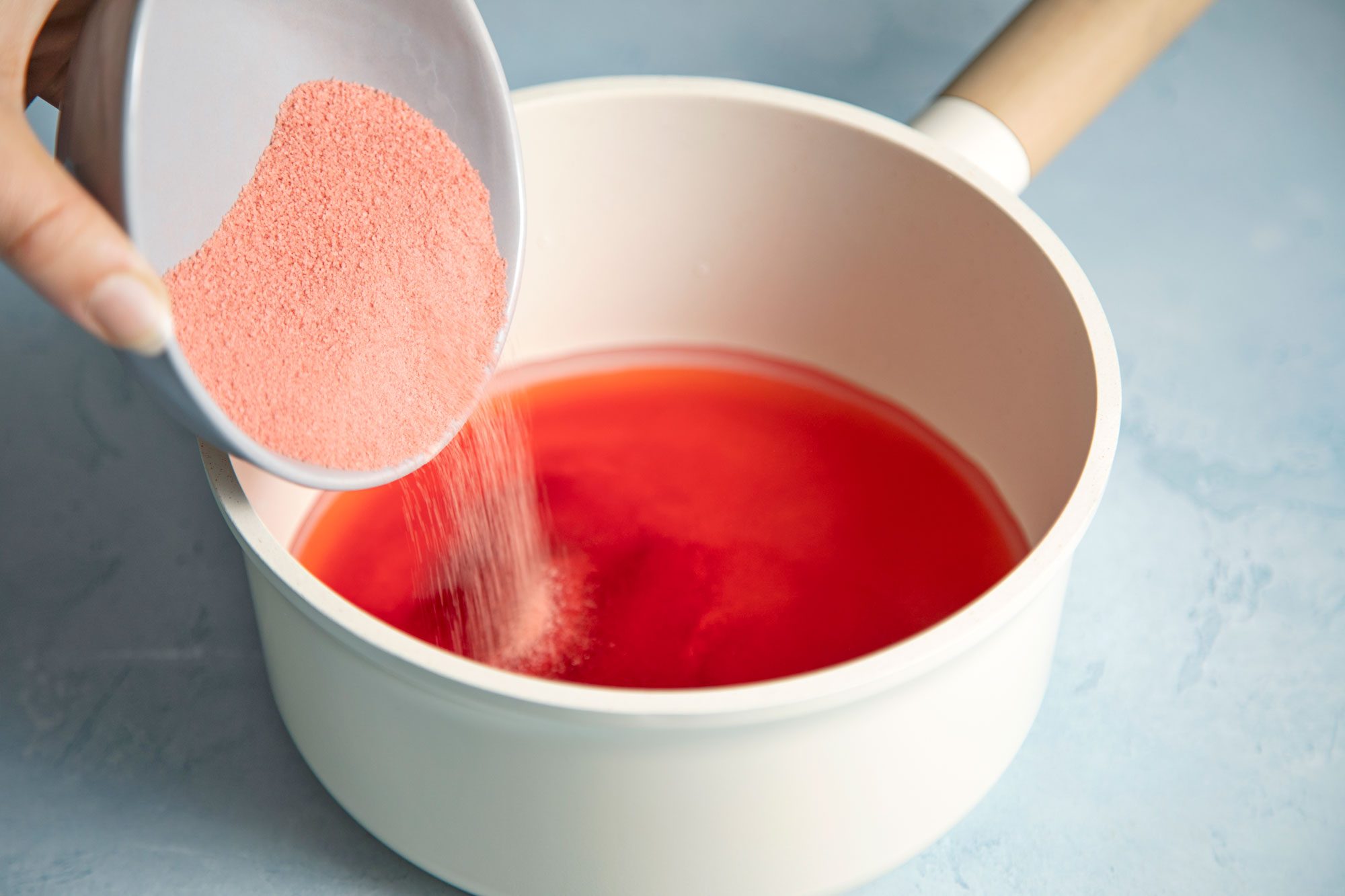 close shot of cherry gelatin mixed with water in a sauce pan