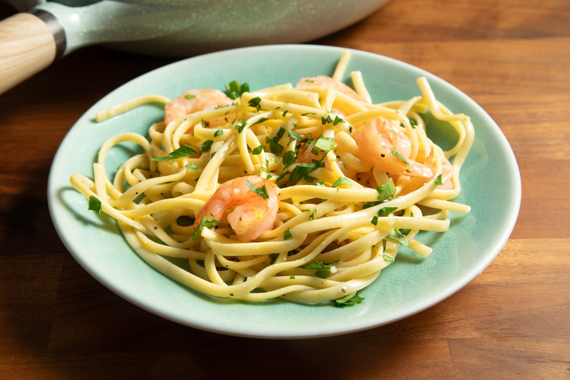 3/4th shot; wooden background; Garlic-Lemon Shrimp Linguine served on plate;