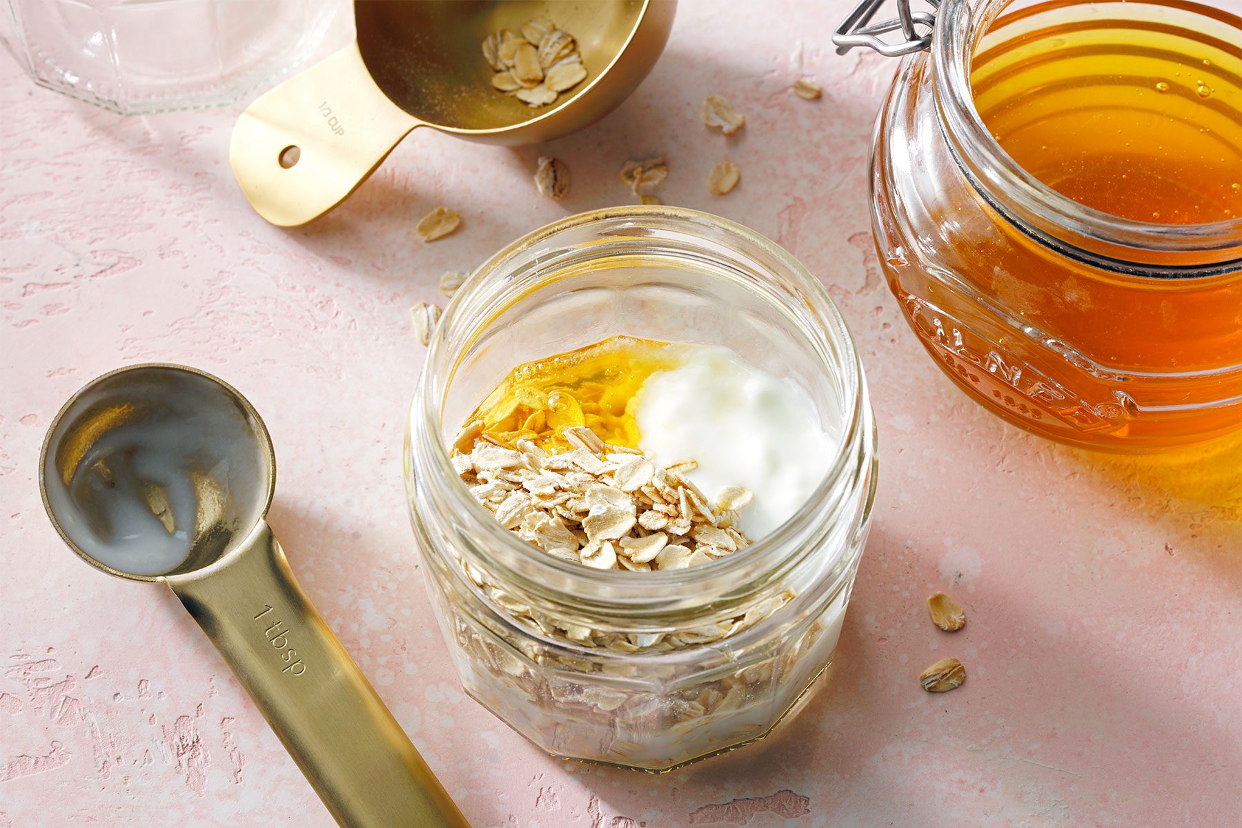 high angle shot of combined oats, milk, yogurt and honey in a mason jar