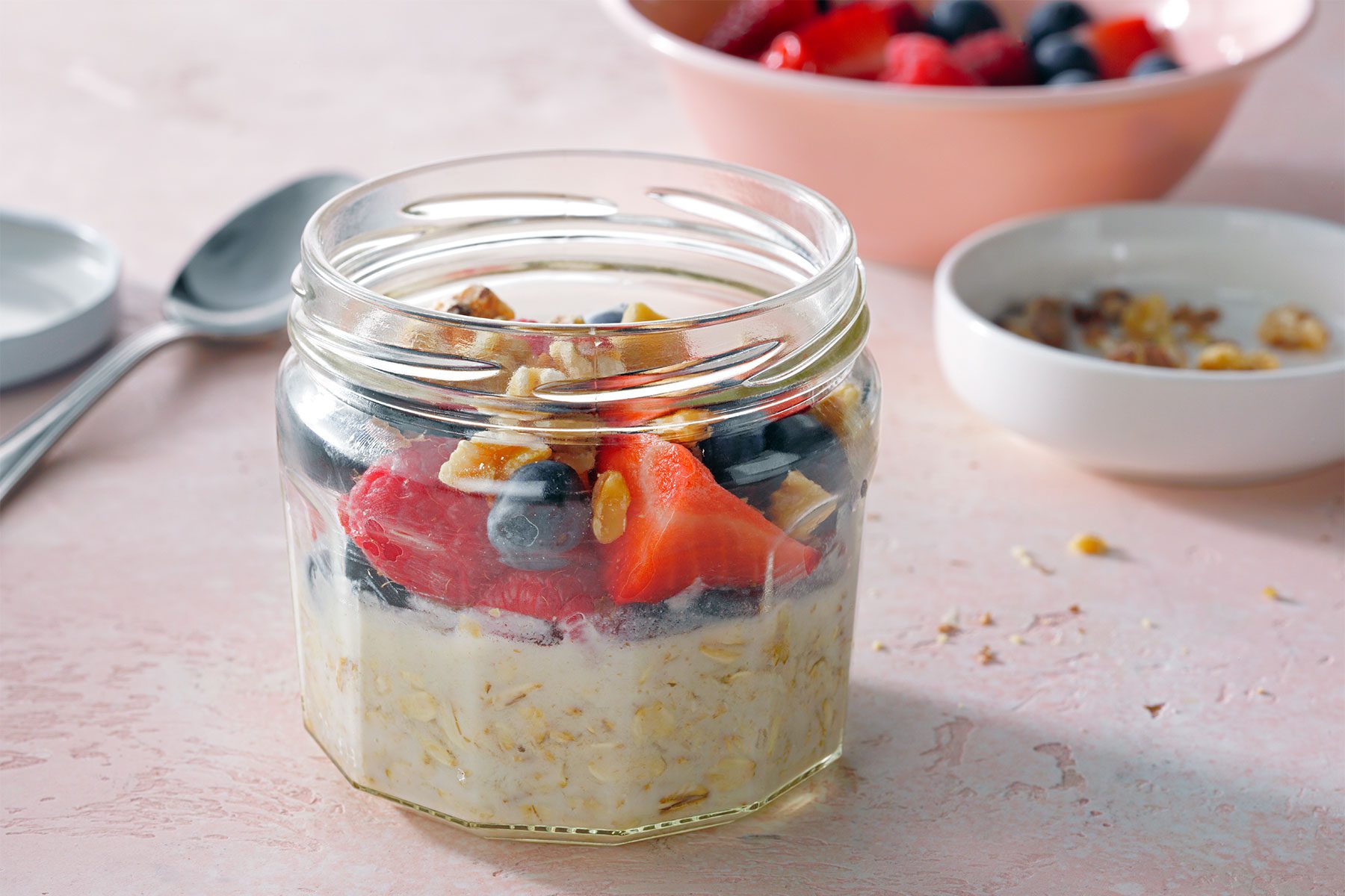 wide shot of oatmeal topped with fruit and nuts in a jar