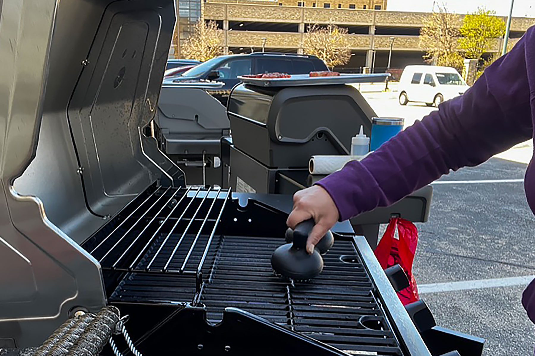 Woman using grill cleaner in parking area