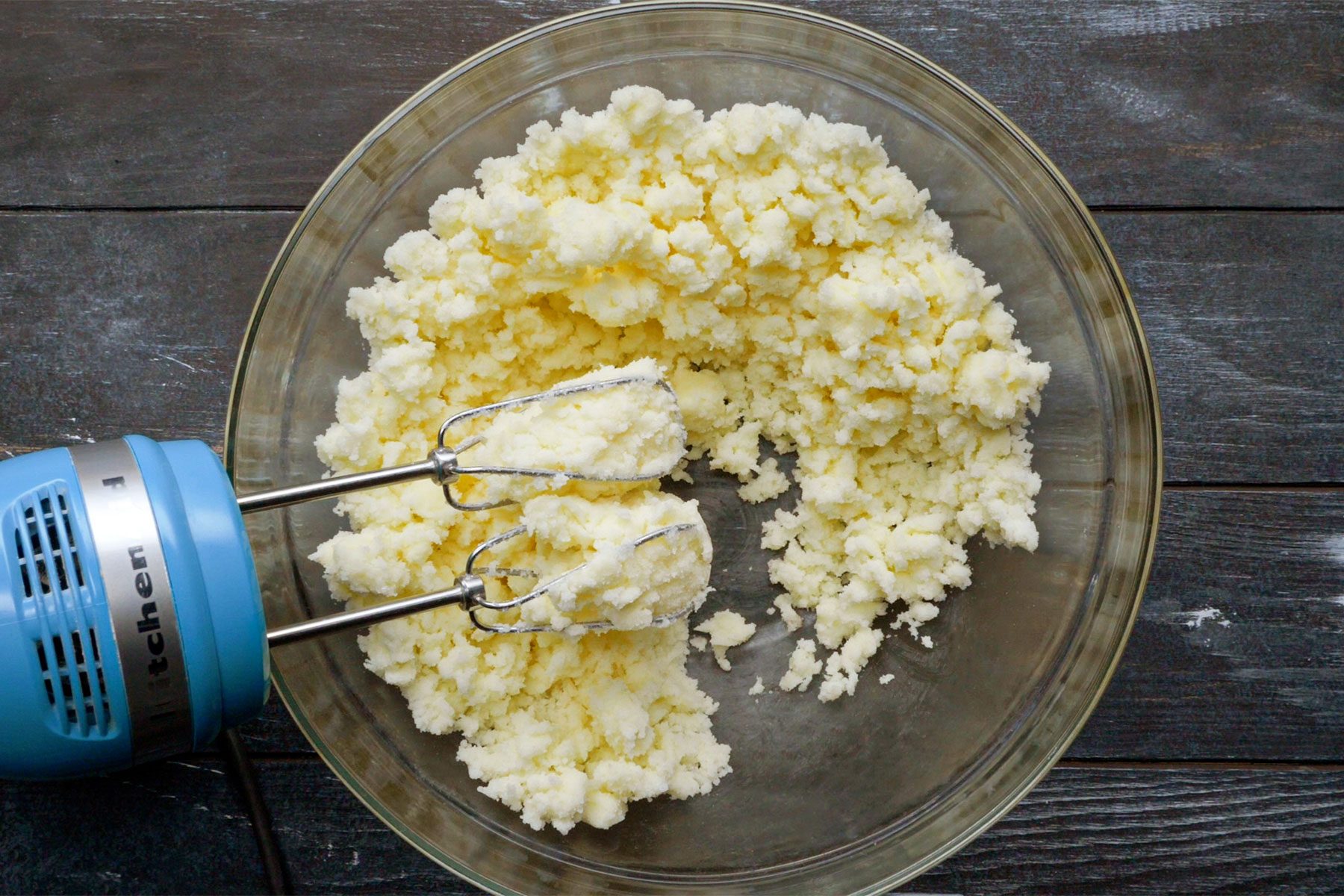 Overhead shot of beaten cream and sugar until light and fluffy; in a large bowl; dark wooden background;