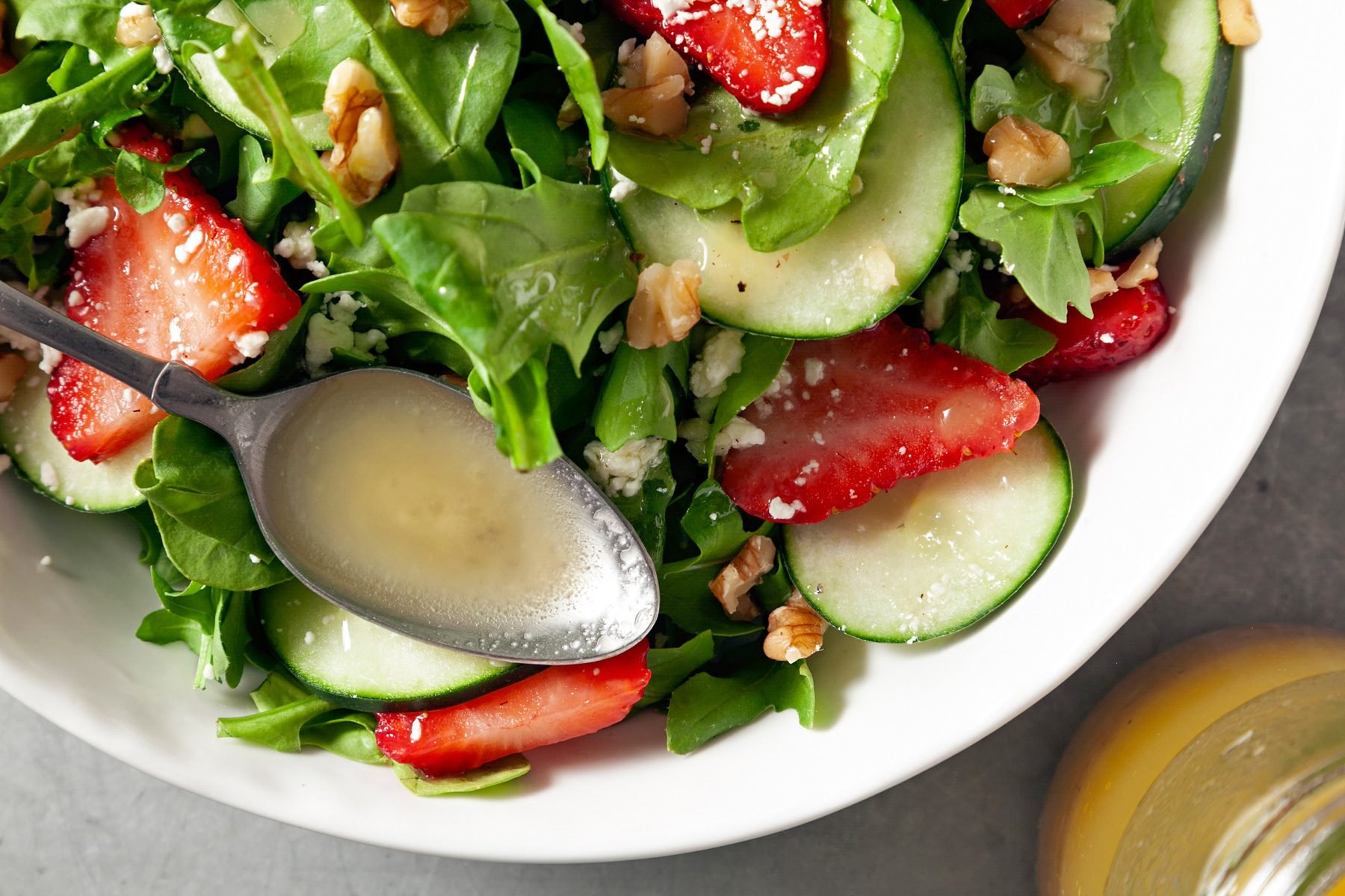 Fresh vegetable salad in a bowl, drizzled with Apple Cider Vinaigrette