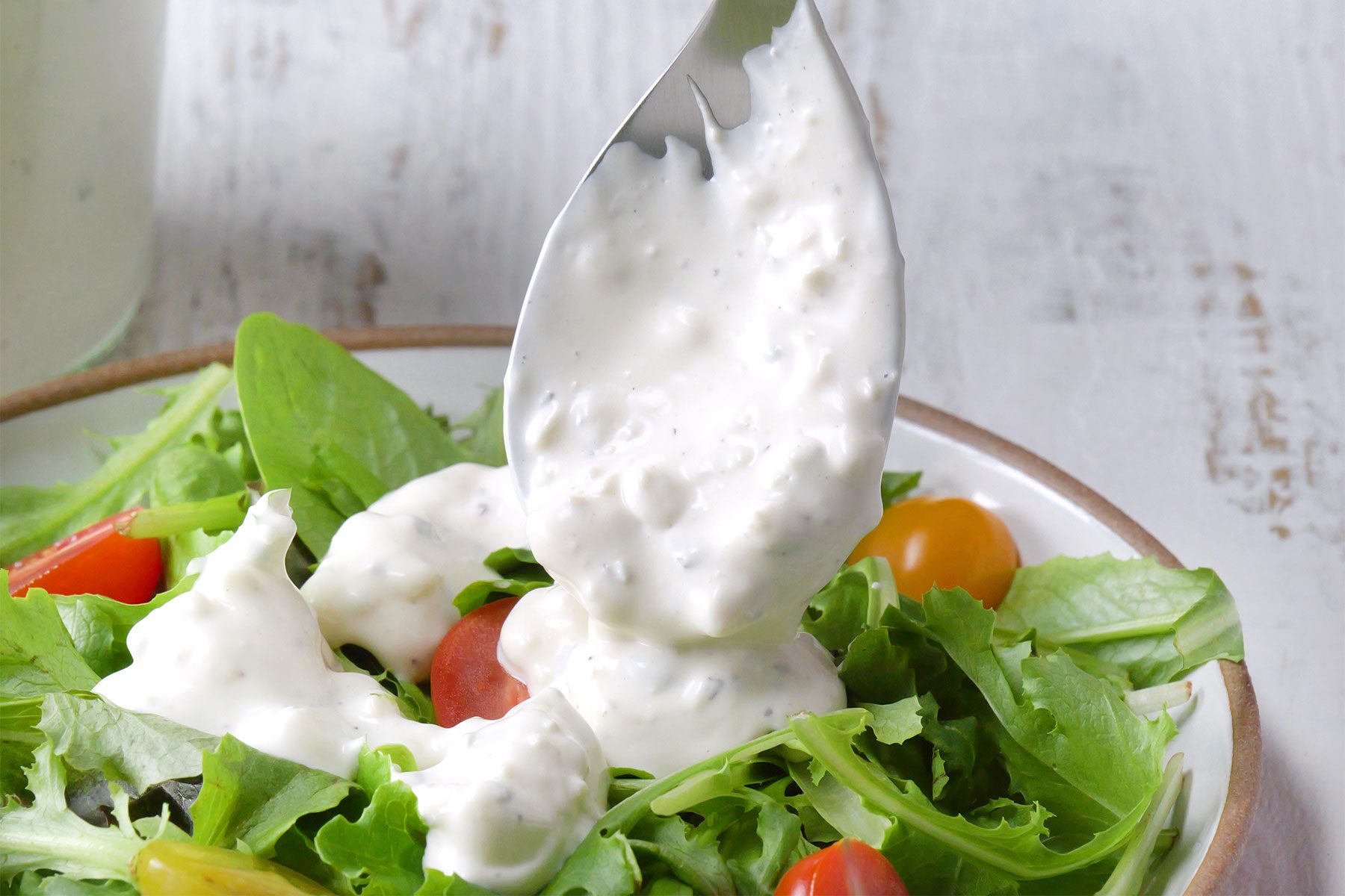 close shot of buttermilk bluecheese dressing served with green salad